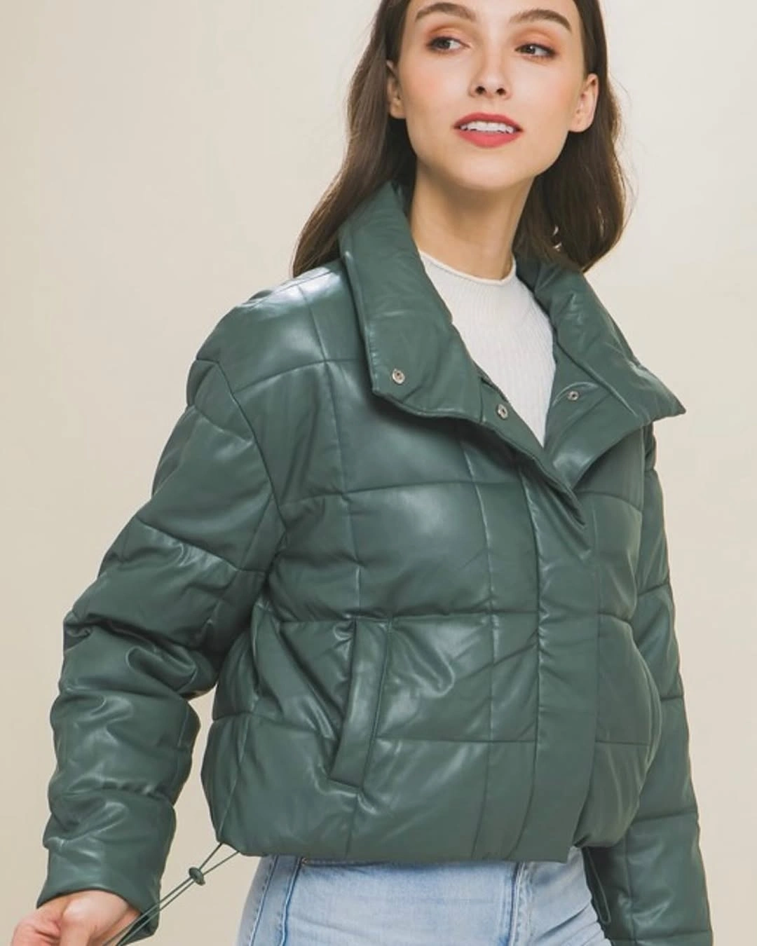 Teal-green cropped puffer with square quilting and light jeans