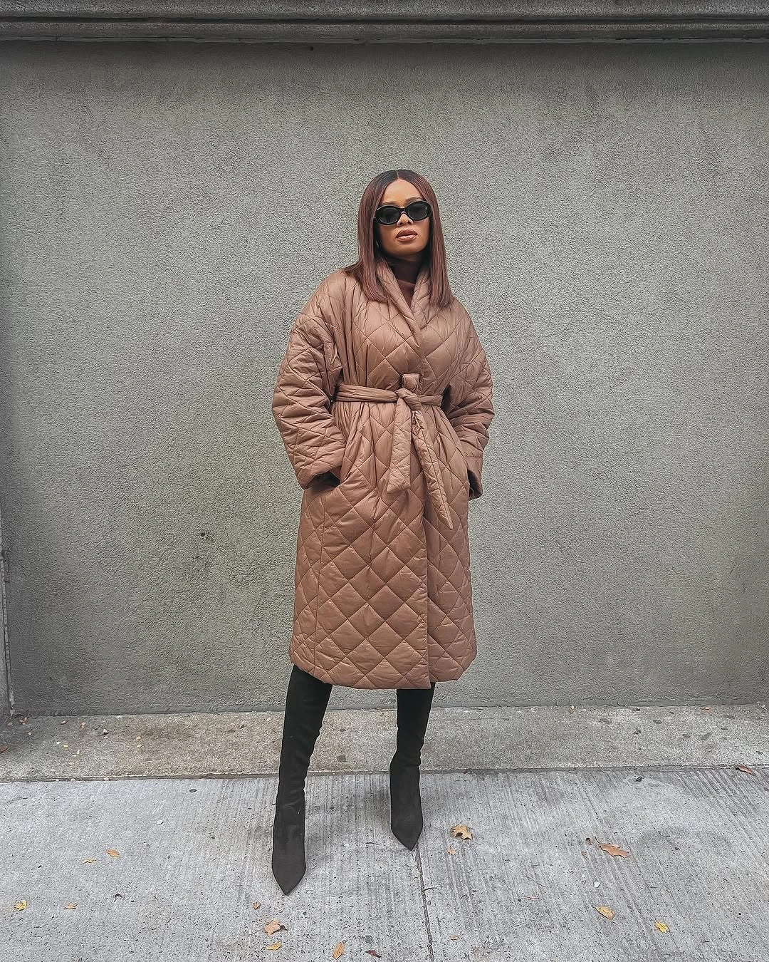 Taupe-brown diamond-quilted puffer coat with black tall boots