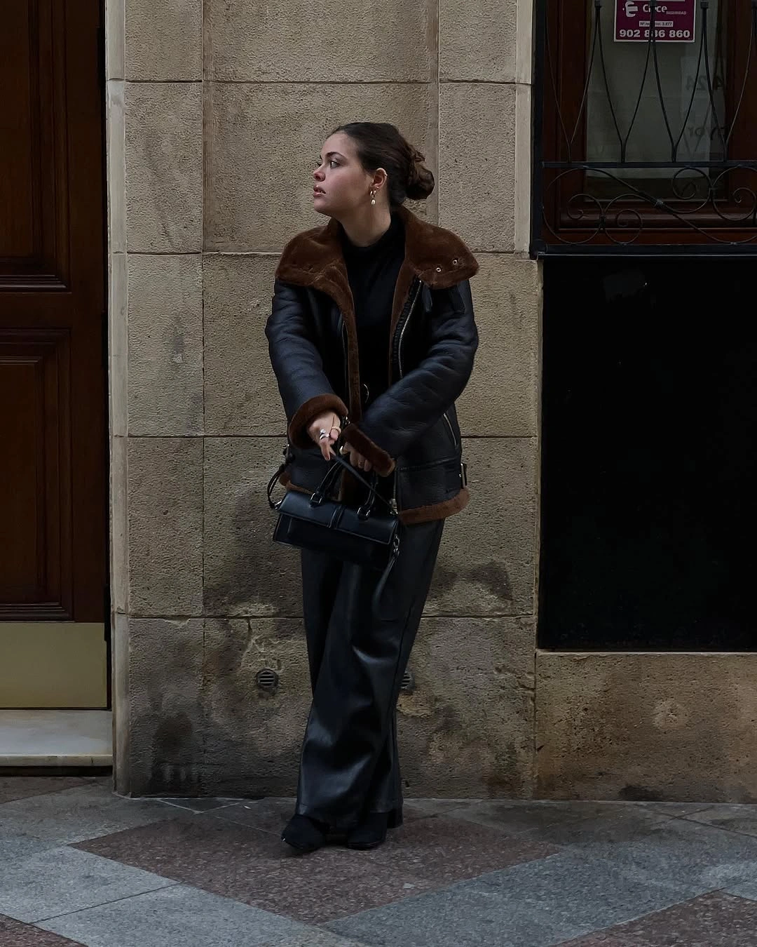Dark cropped jacket with plush brown trim and wide trousers