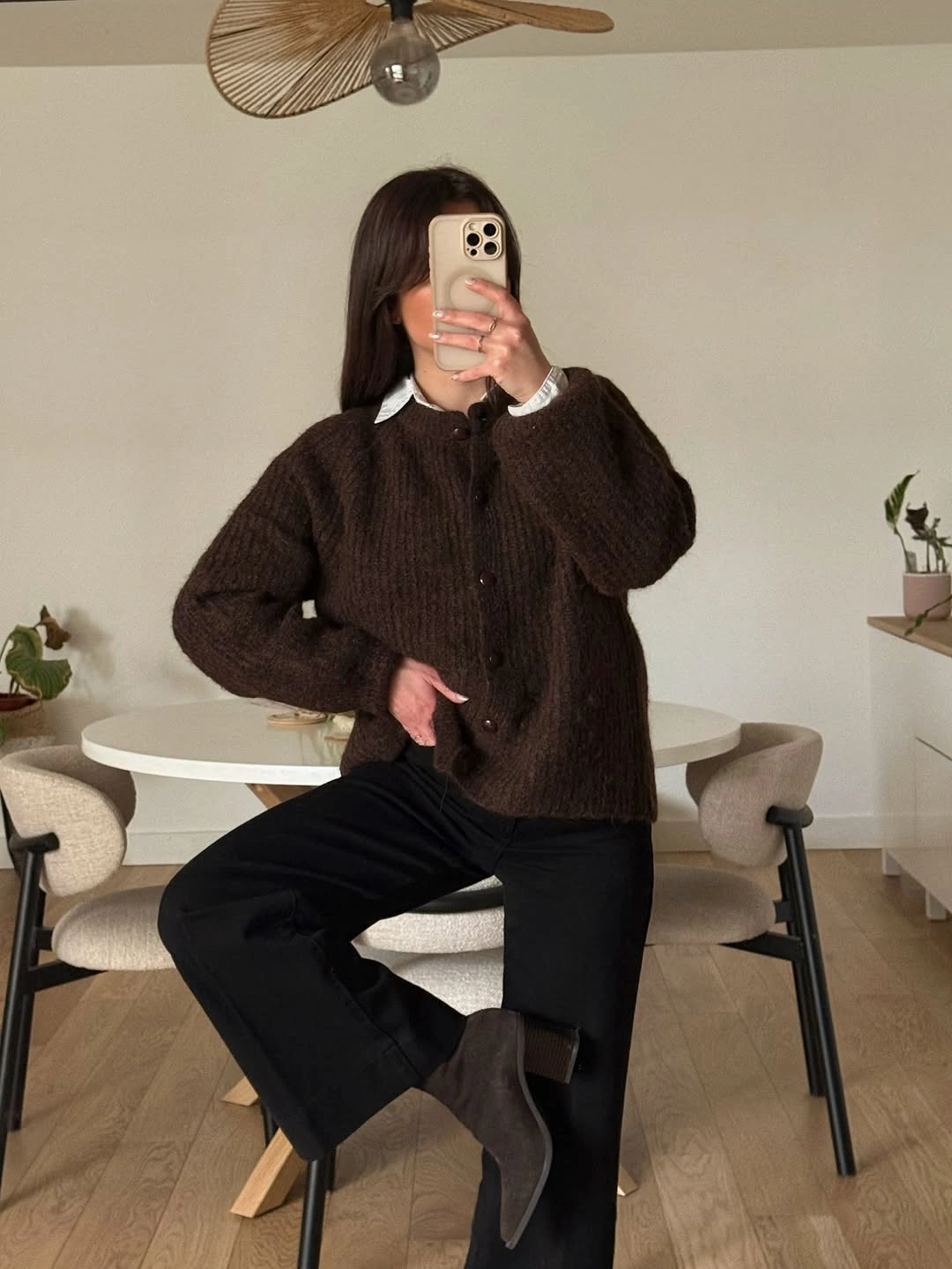 Brown fuzzy cardigan with white collar and black trousers