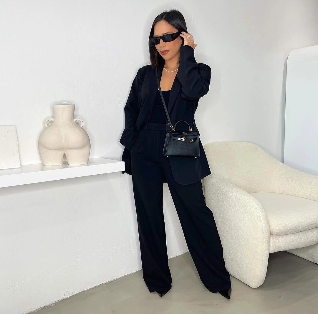 Oversized black blazer with wide trousers and small waist bag