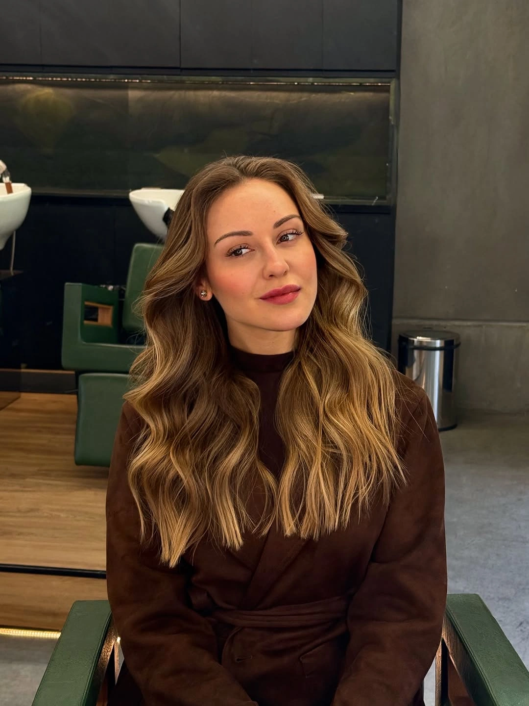 Long brunette waves with warm caramel ribbons and deeper roots
