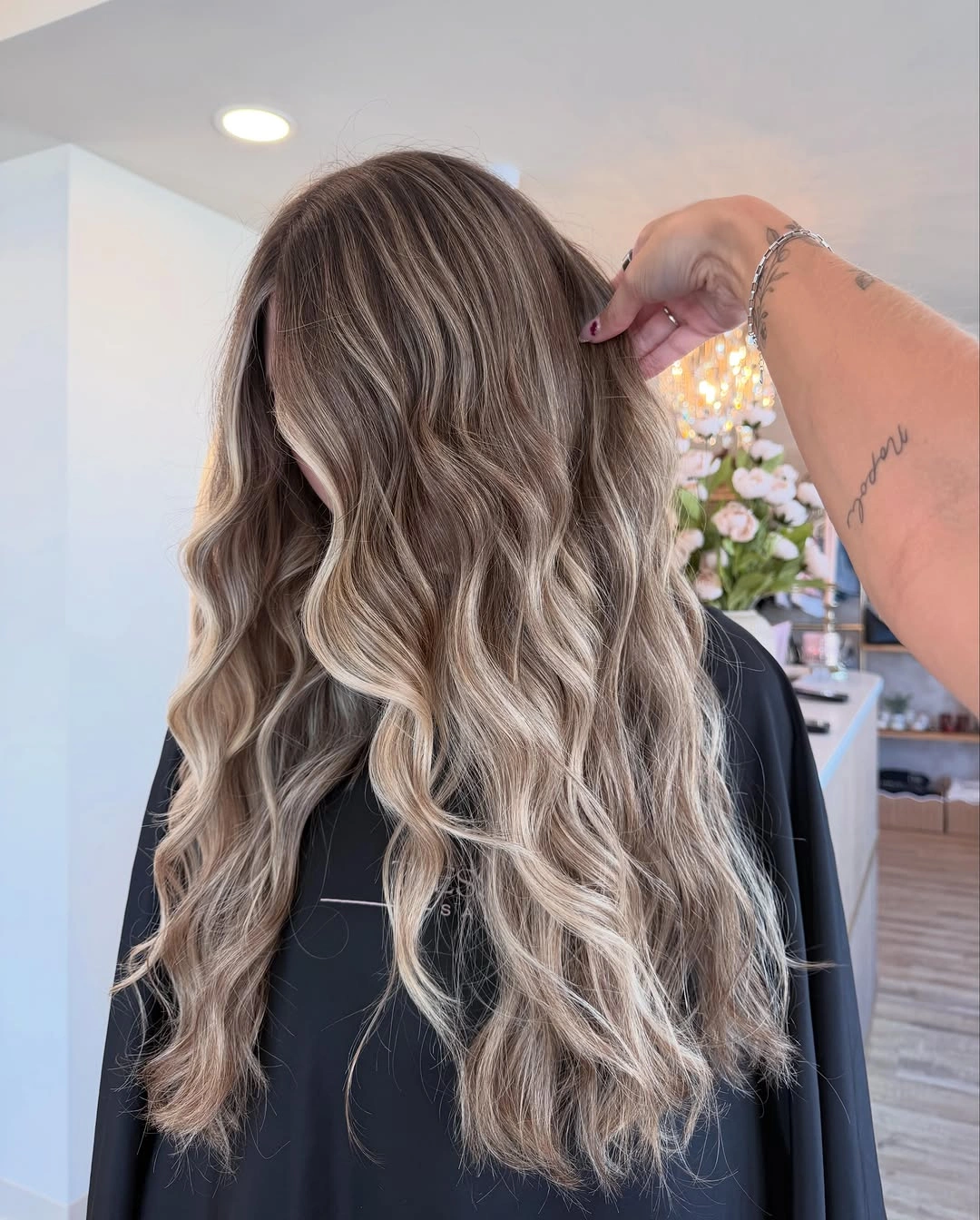 Long cool ash-beige waves with muted root depth and soft shine