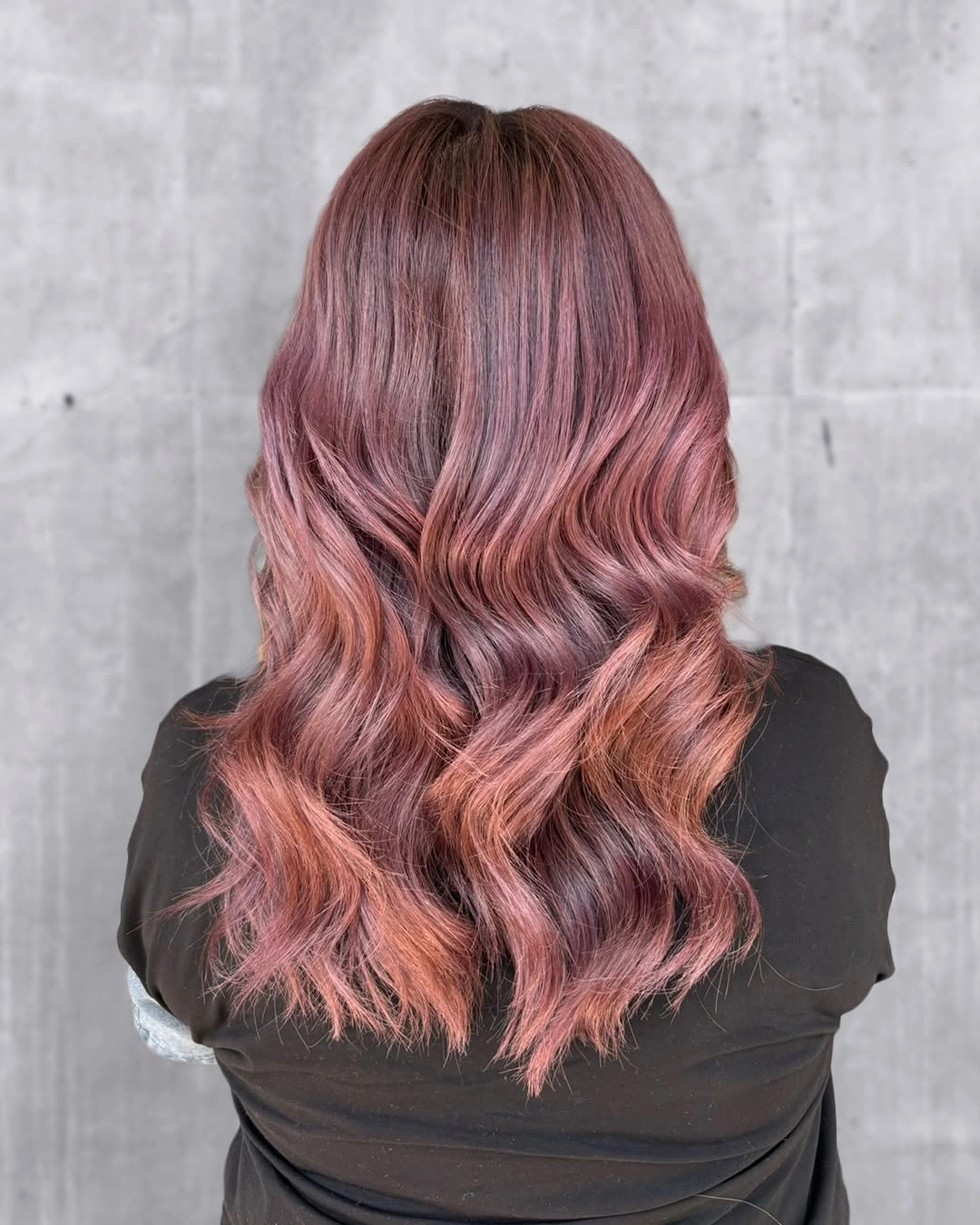 Long burgundy waves fading into dusty rose-pink curled ends