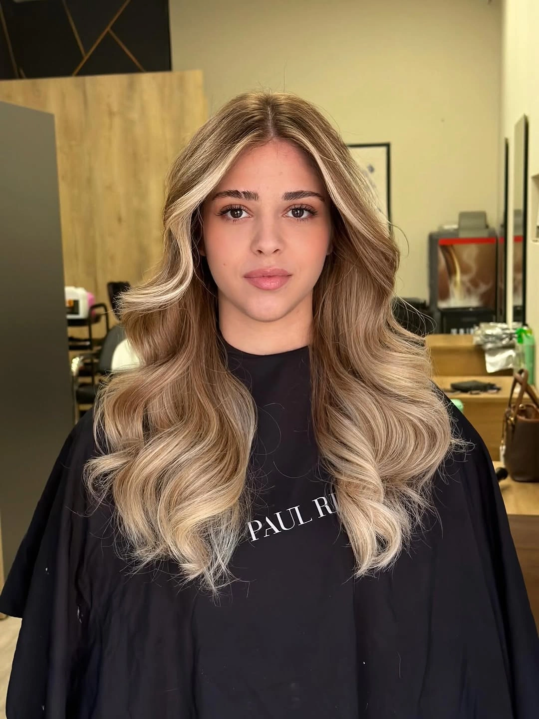 Long beige-blonde waves with darker shadow root and airy light ends