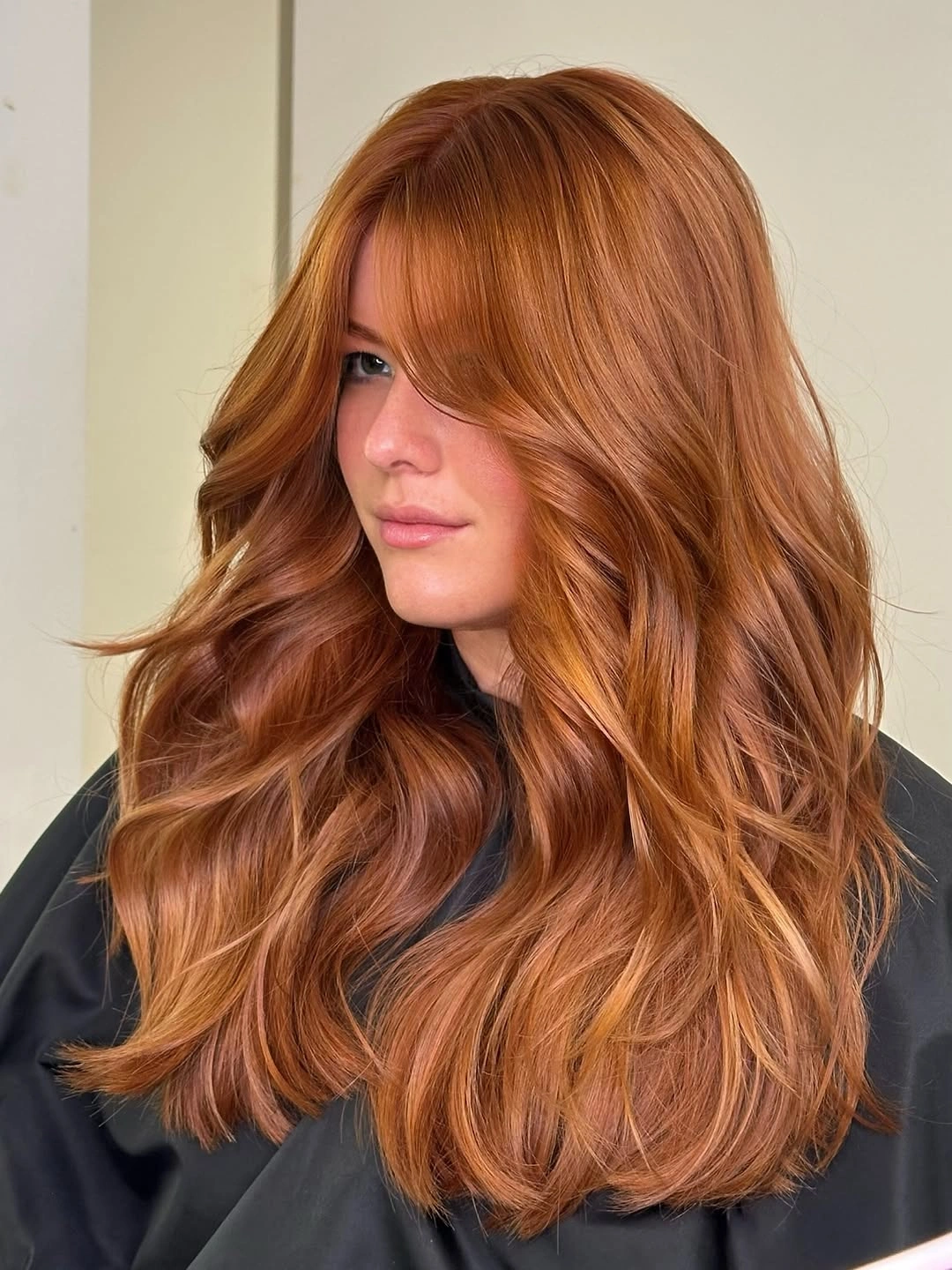 Long copper layered waves with soft curtain fringe around the face