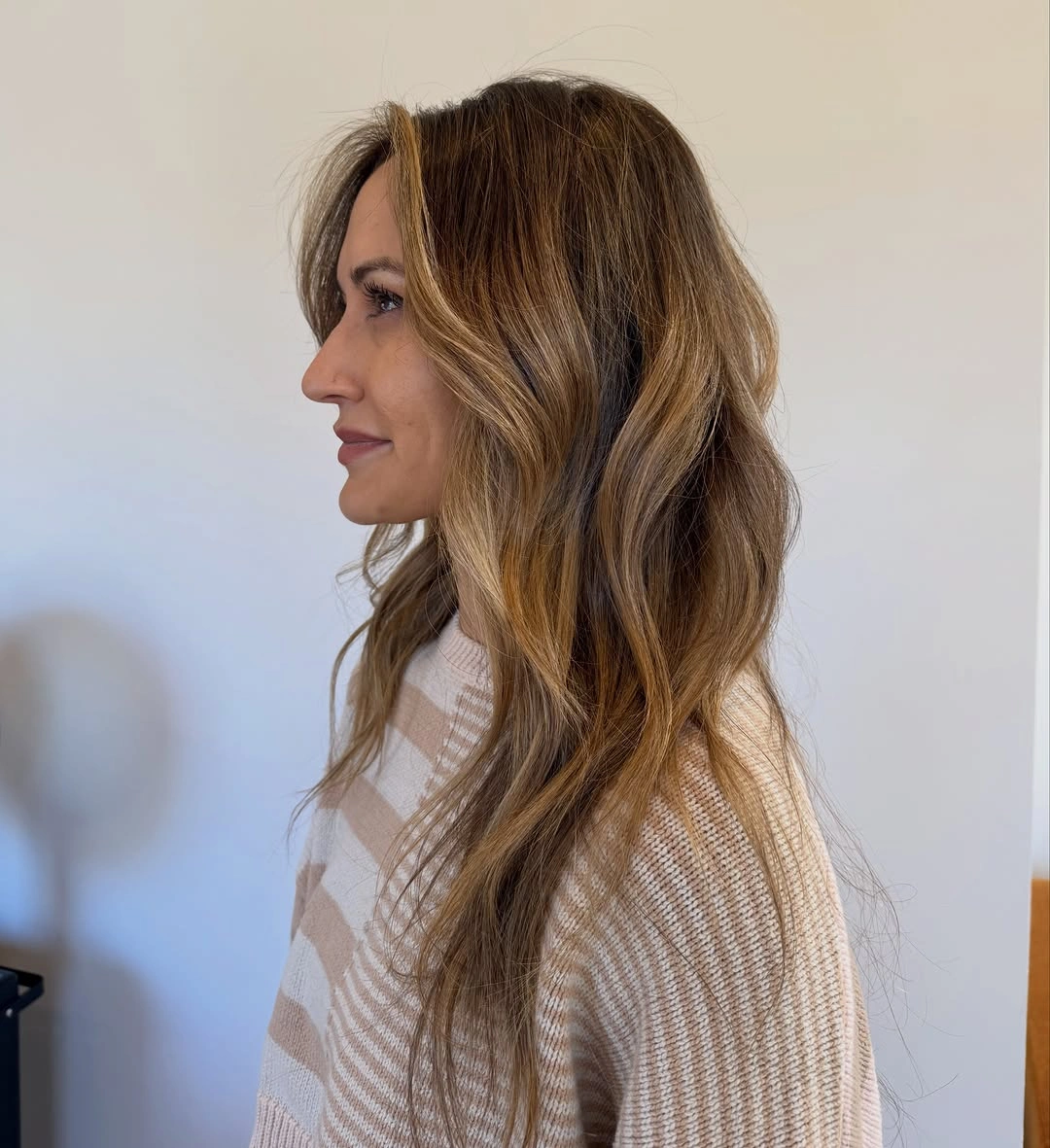 Shoulder-length brown waves with beige face-framing color pieces