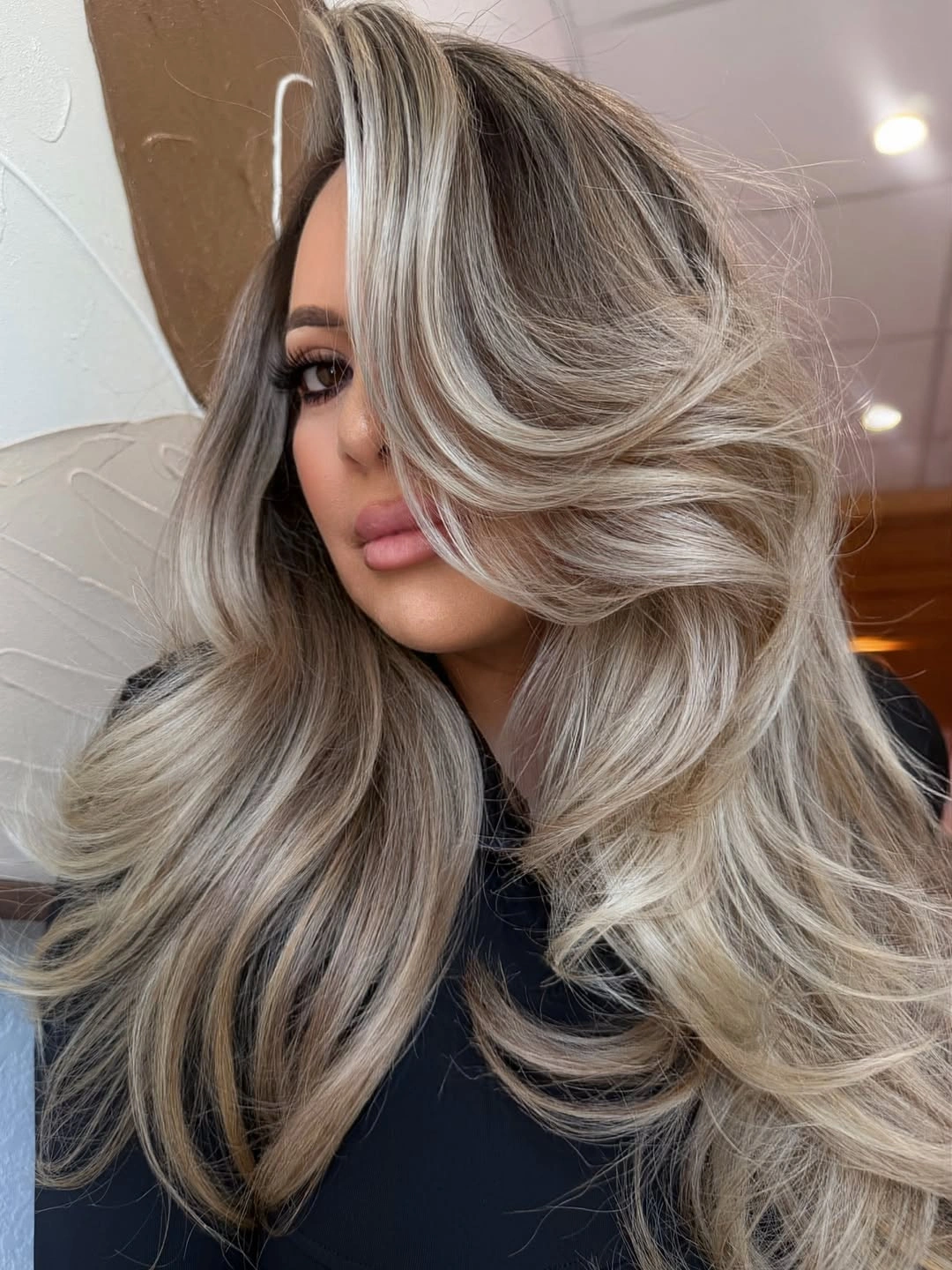Voluminous silver blonde layers with dark root and wide ribbons