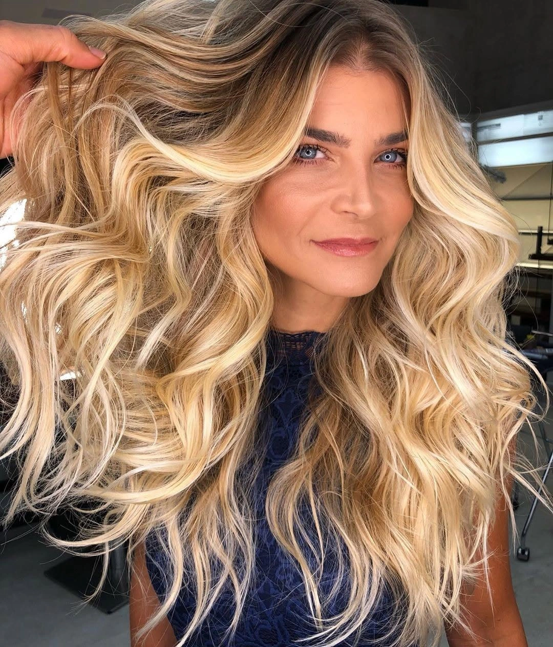 Long voluminous blonde curls with darker roots and wide ribbons