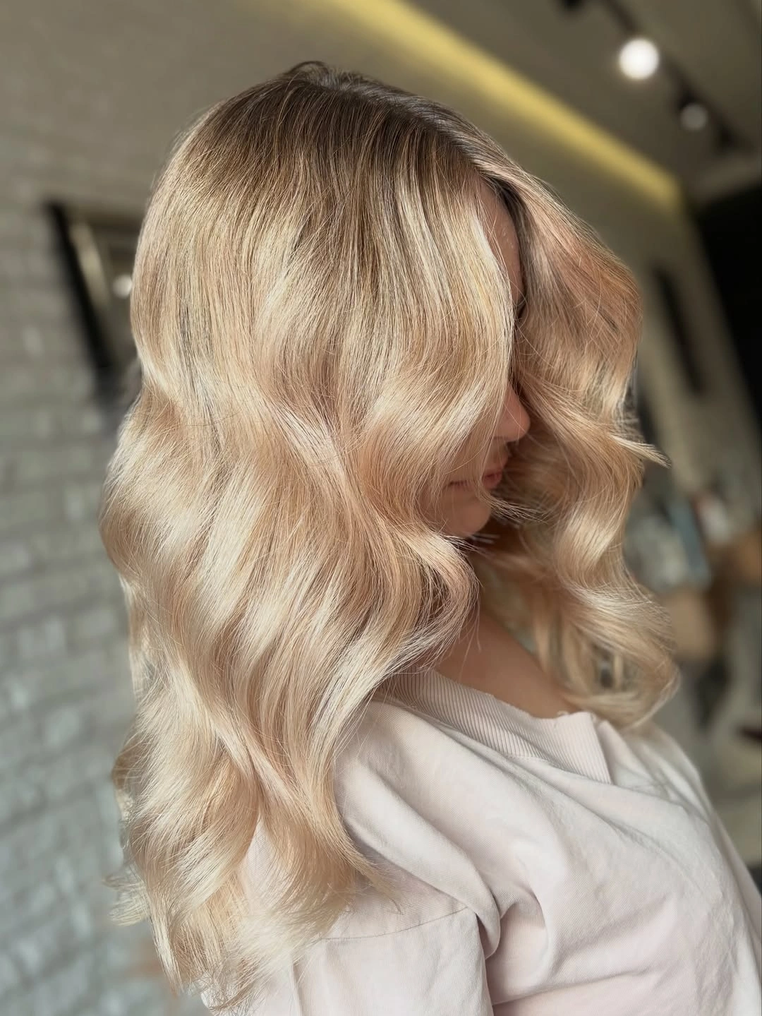 Medium champagne blonde waves with soft root shadow