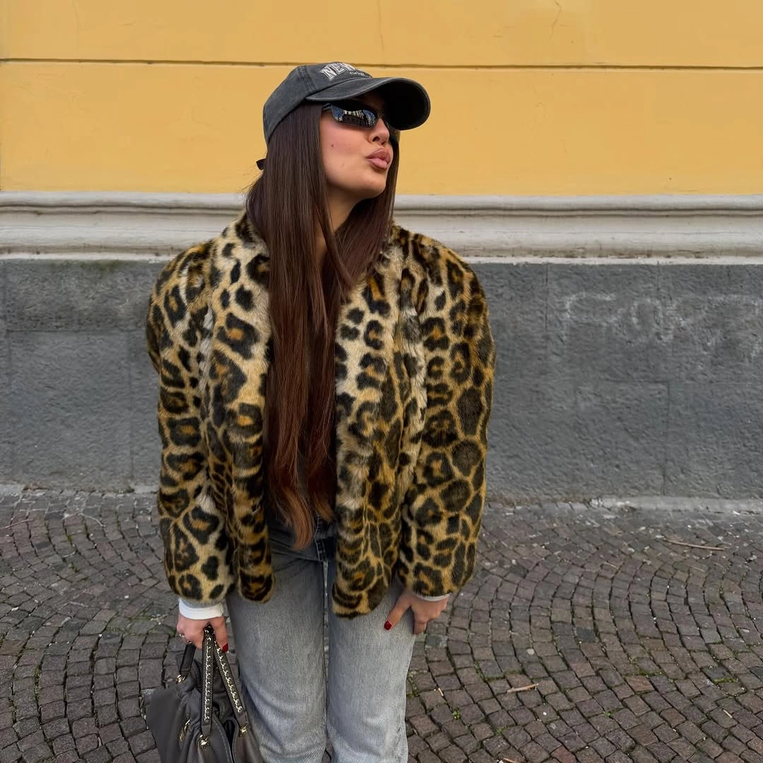 Leopard textured jacket with blue jeans, dark cap, and sunglasses
