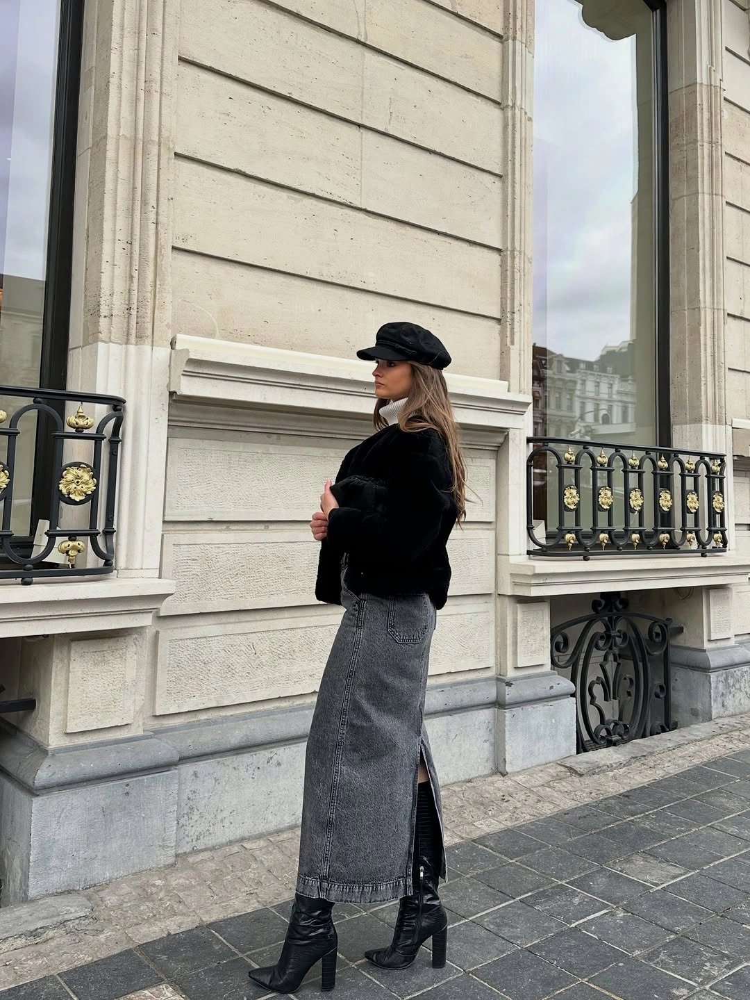 Black textured top with gray column skirt, cap, and ankle boots