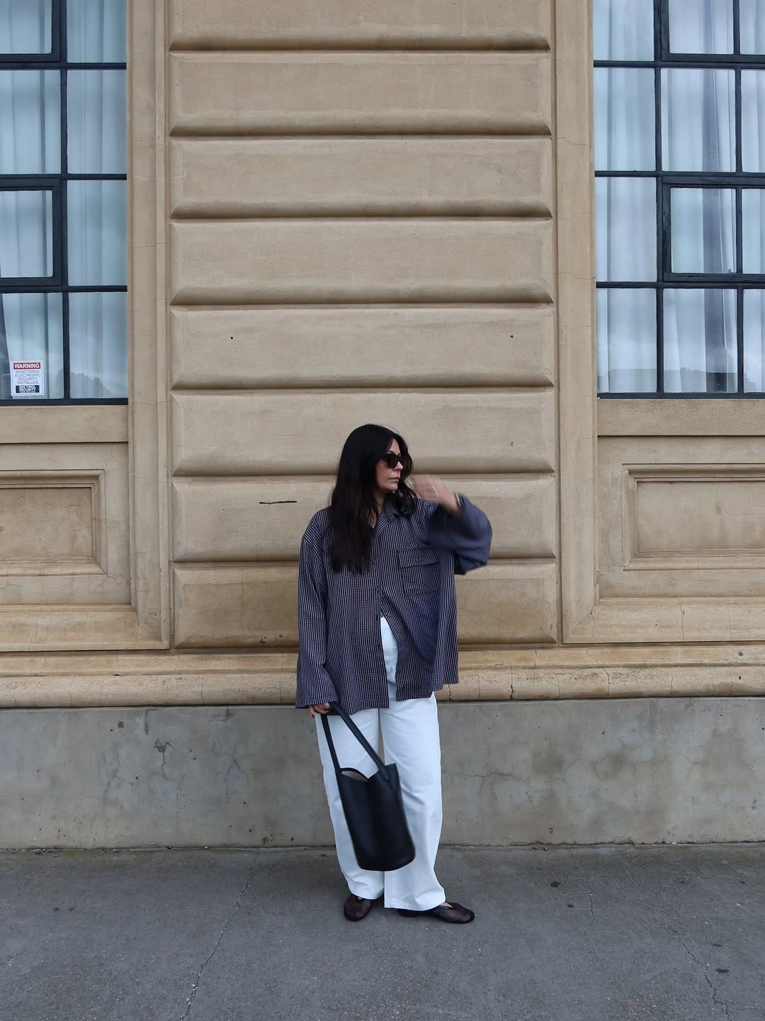 Slouchy charcoal top with pale wide-leg trousers and black tote bag