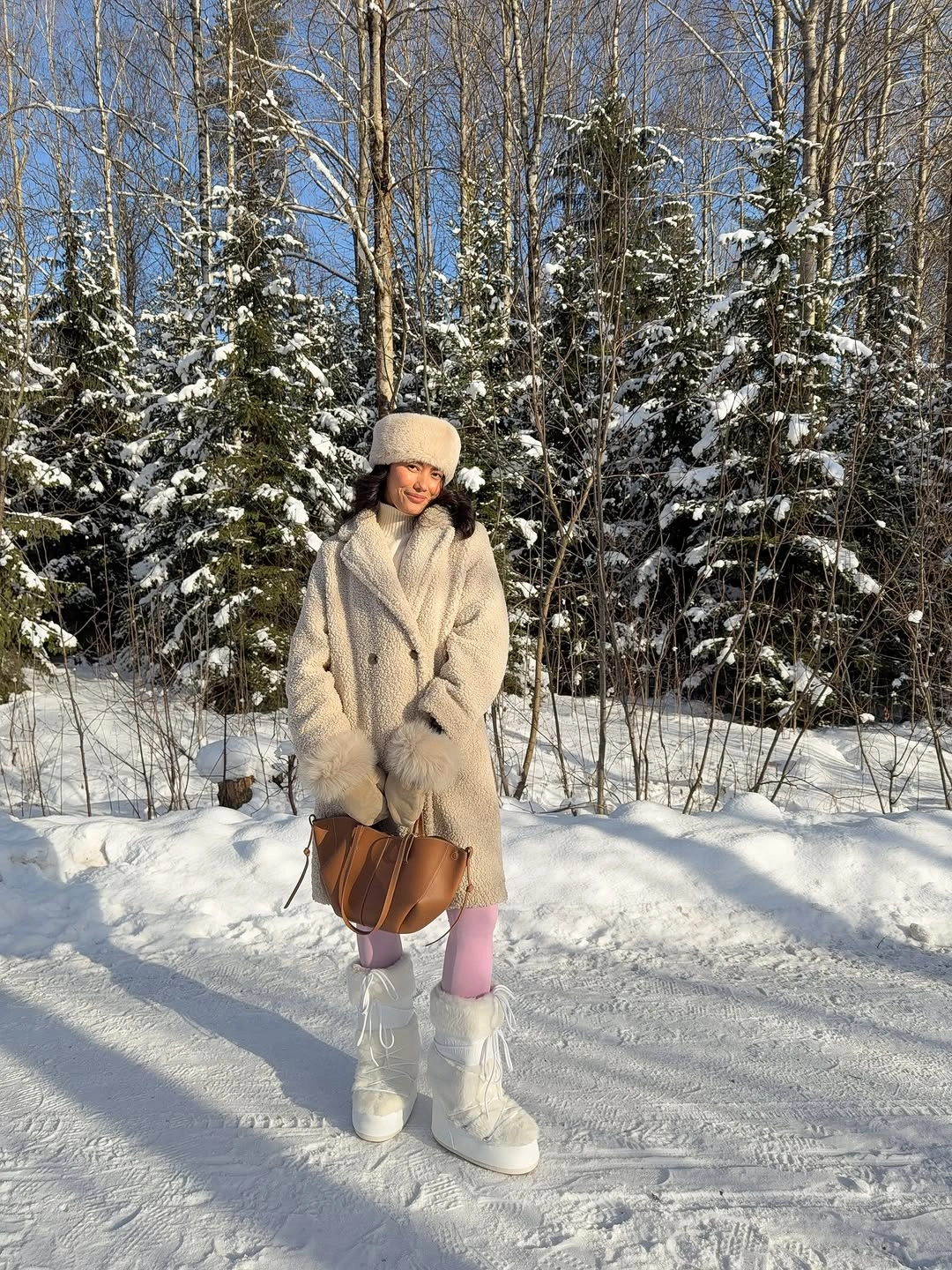Cream textured jacket with pink trousers, white boots, and cognac bag