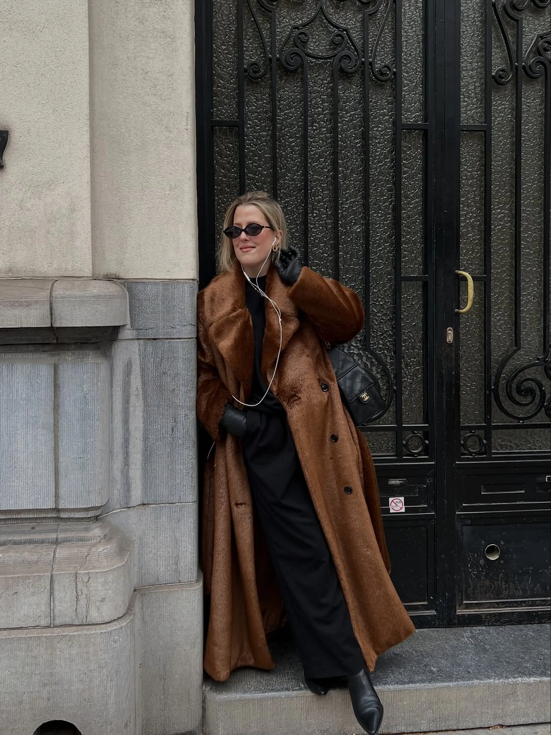 Long brown fuzzy-textured coat over flowing black layers and boots