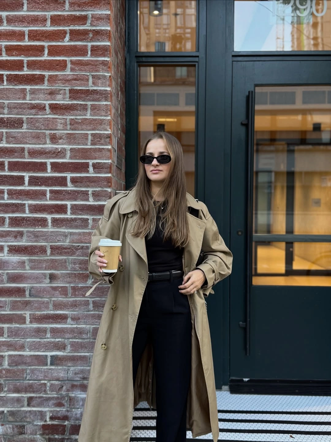 Long beige coat over black top and trousers