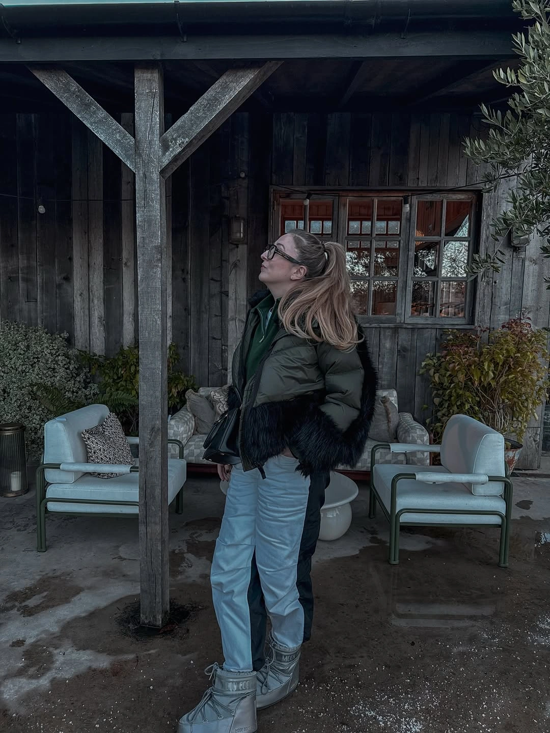 Dark green cropped jacket with pale blue trousers and gray boots