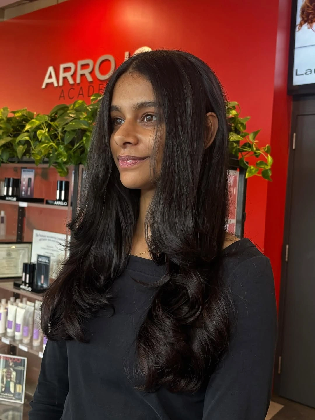 Black-brown center-parted hair with softly curled lower lengths