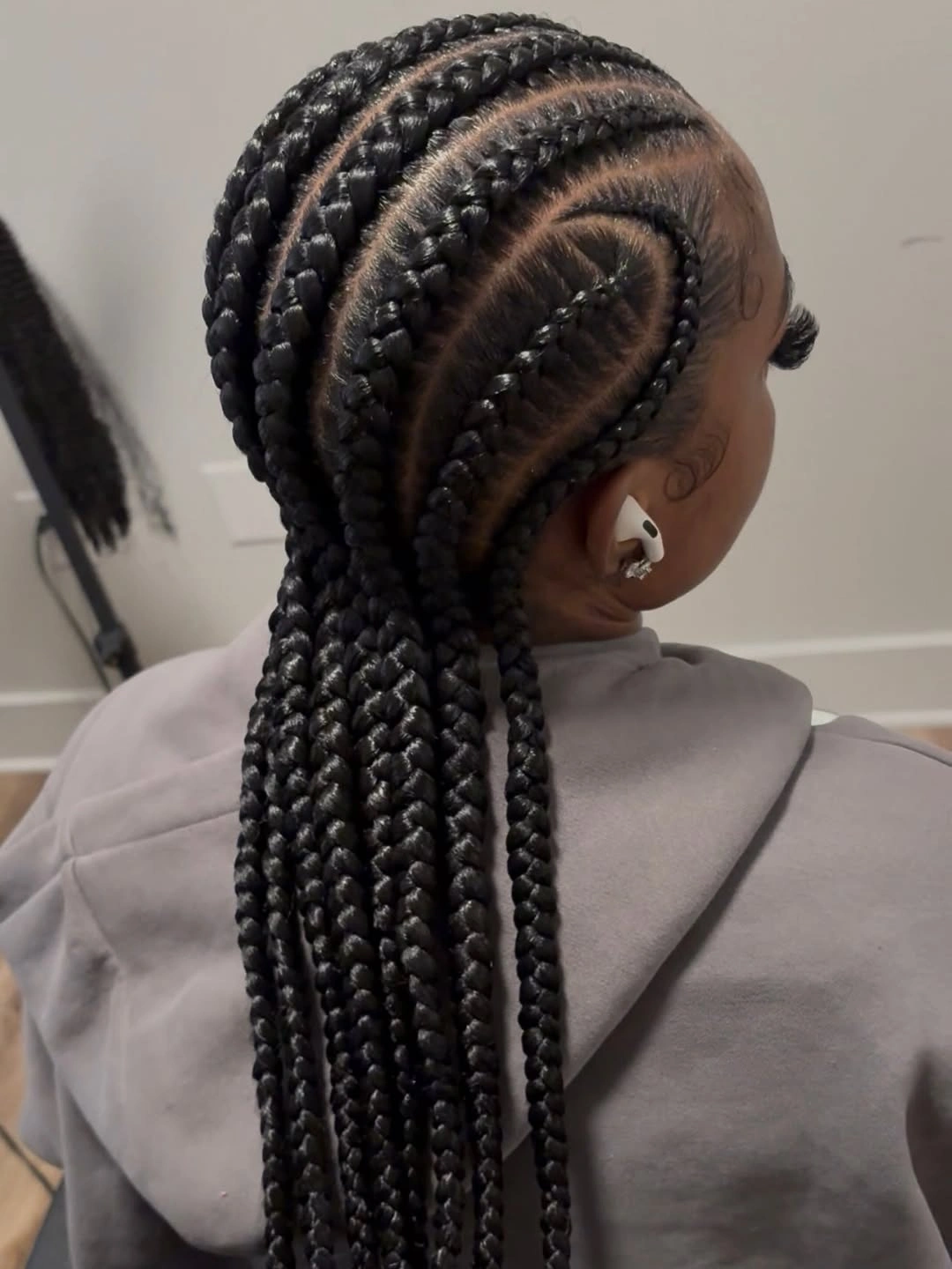 Long black cornrow-style braids with curved scalp arcs