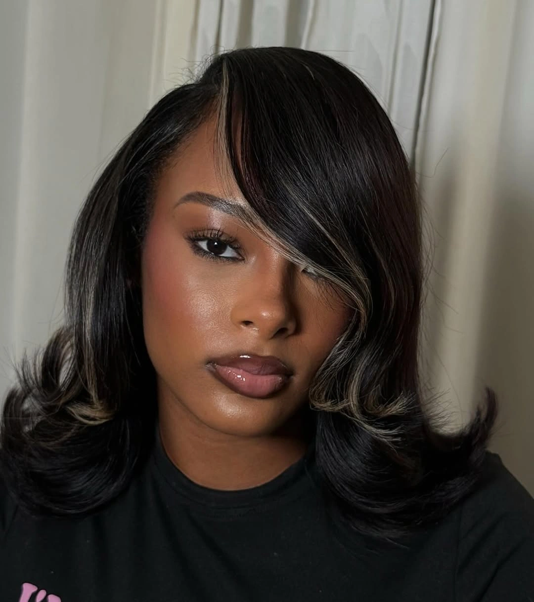 Shoulder-length dark layers with beige-blonde face streak and flipped tips