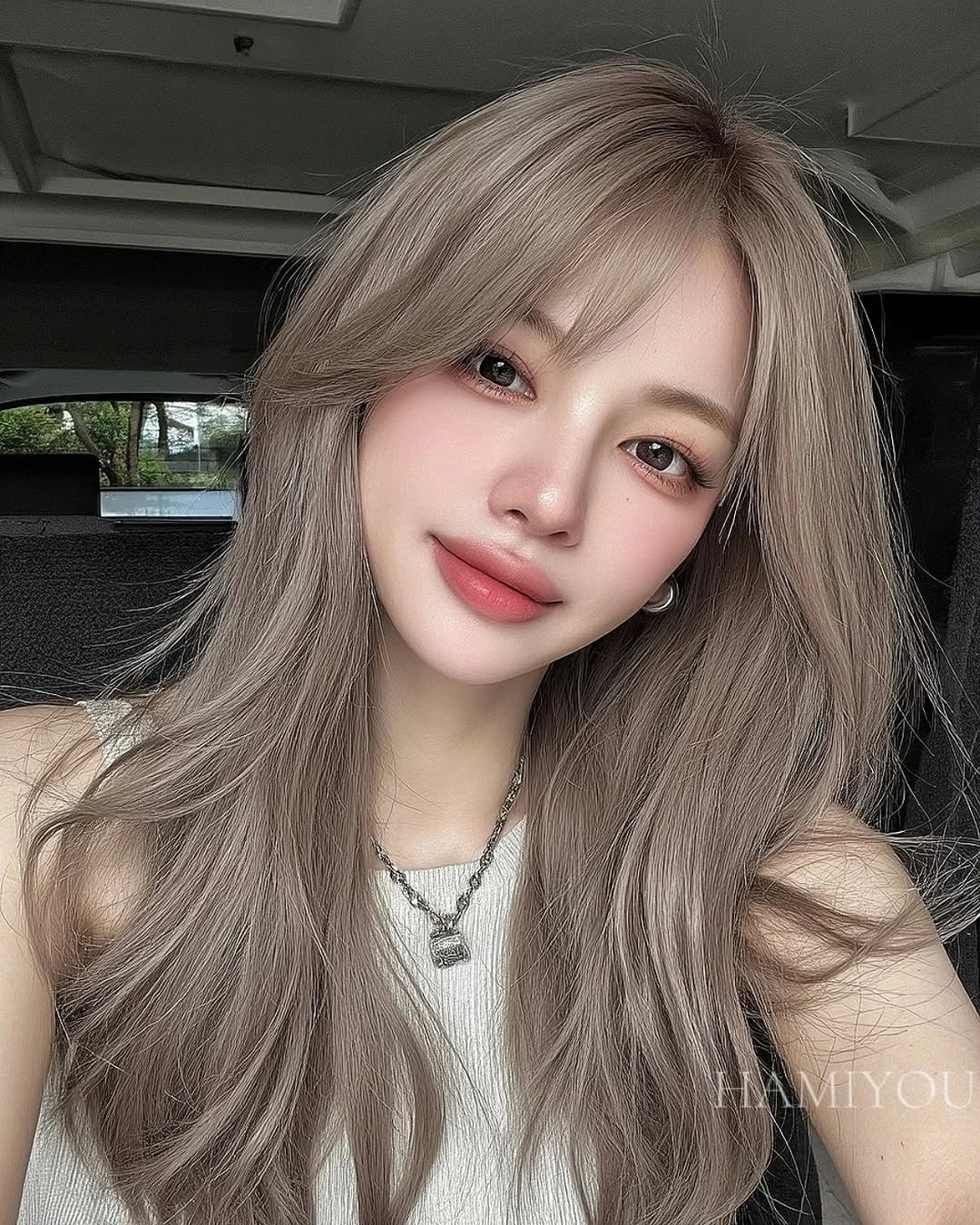 Long ash taupe hair with wispy bangs and layers