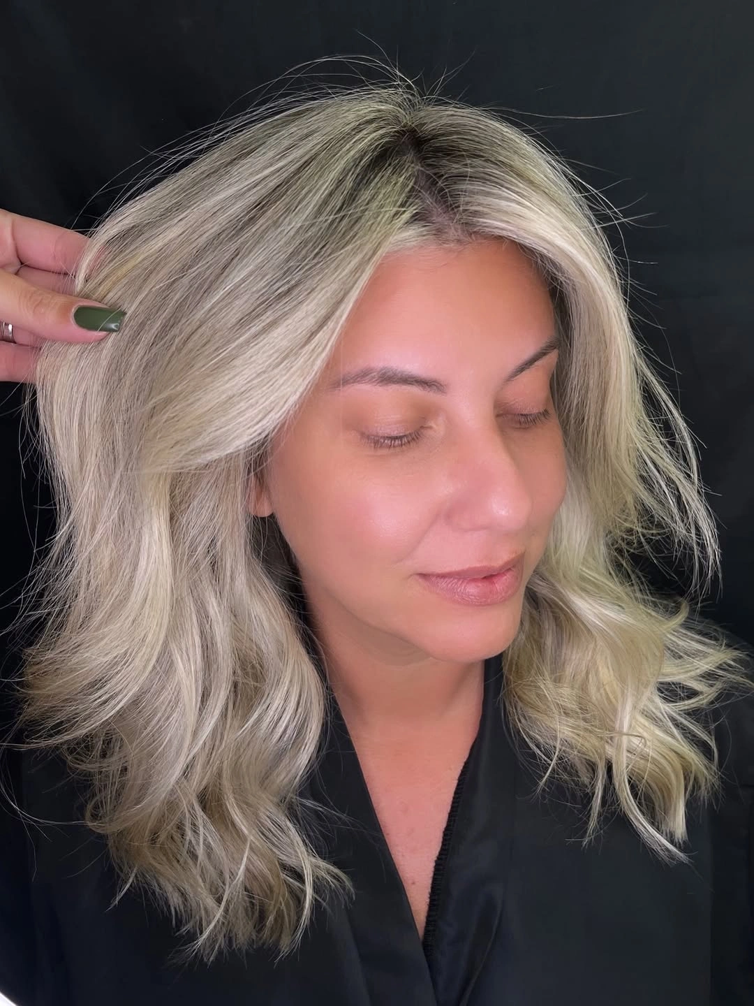 Tousled shoulder length blonde hair with darker roots