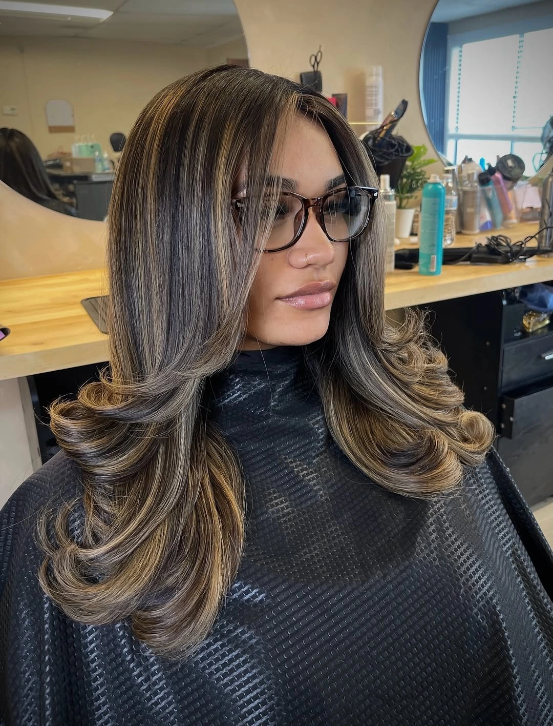 Long dark hair with face-framing layers and outward-curved ends