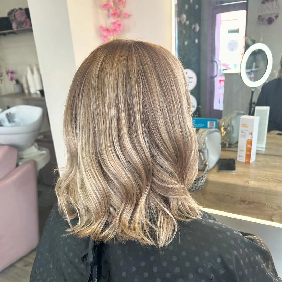 Shoulder-length blonde hair with even perimeter and softly flicked ends