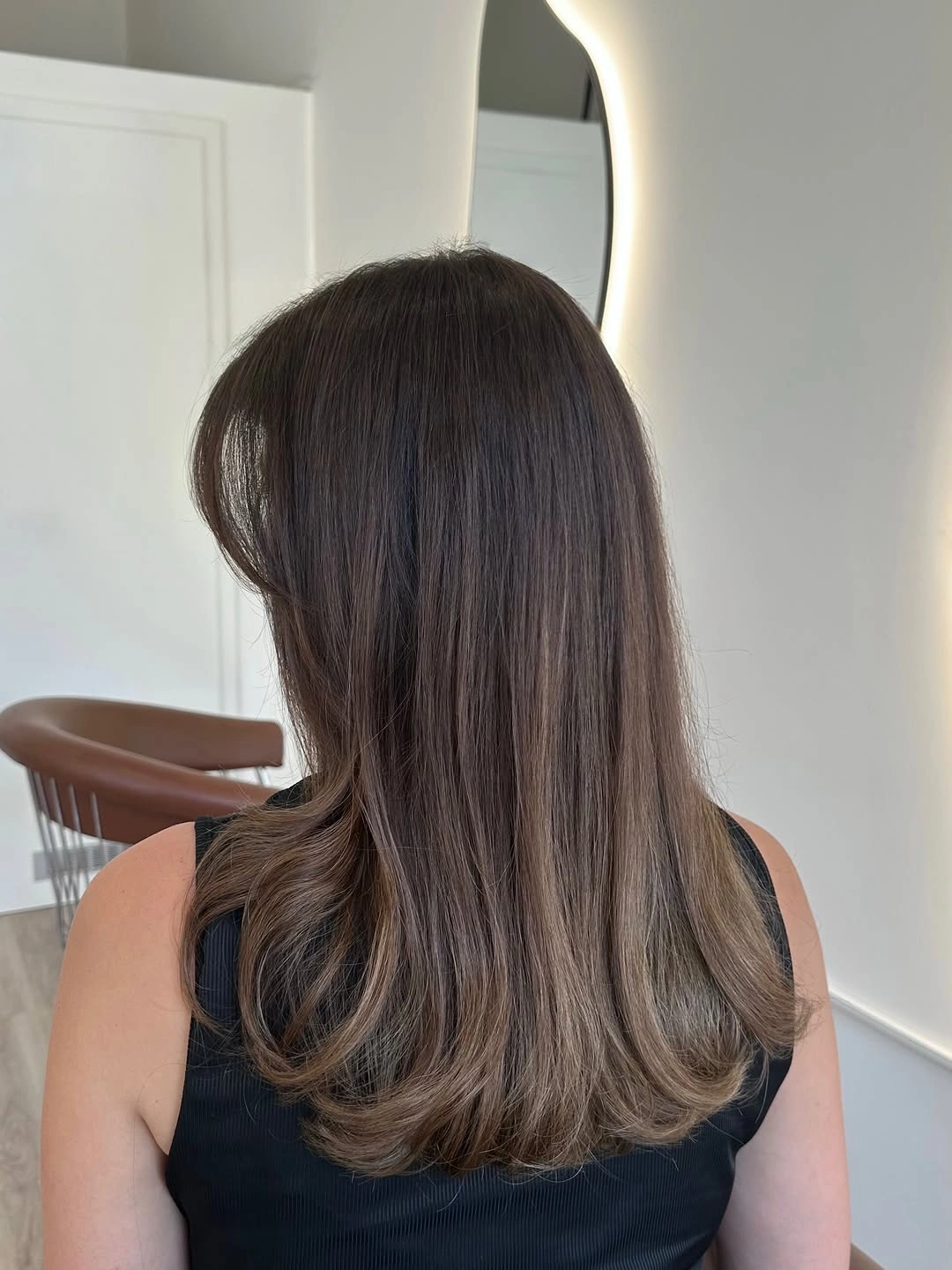 Straight medium-to-long hair with dark roots and lighter ends