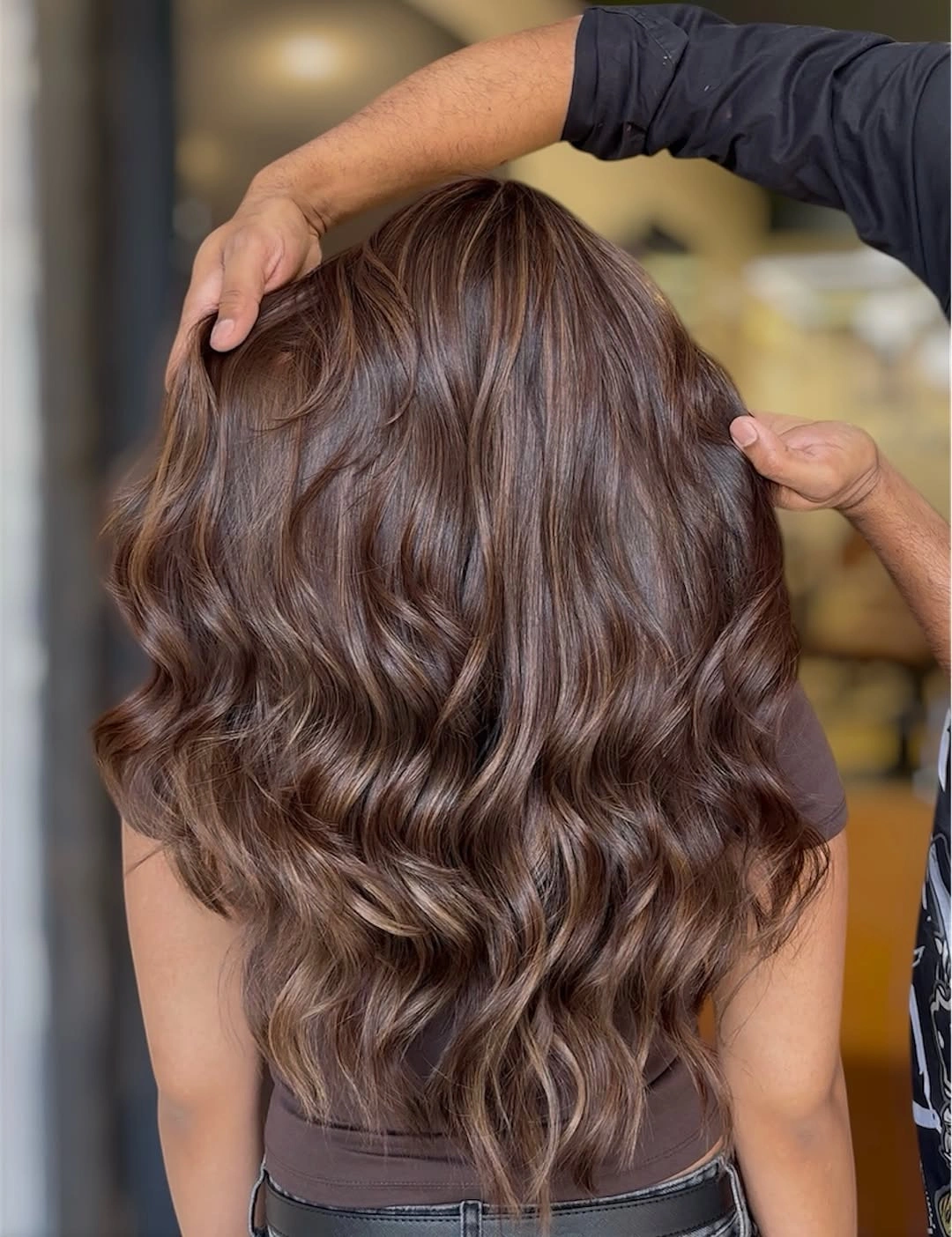 Long brown hair with broad waves and rounded lower silhouette