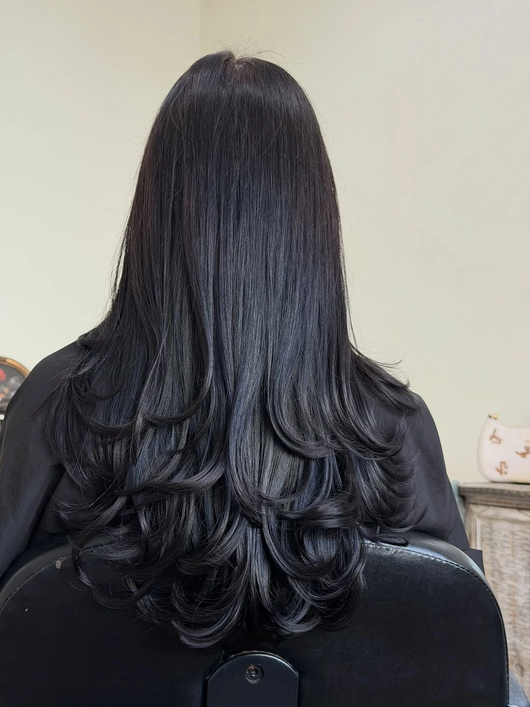 Long glossy dark layered hair with rounded curled ends