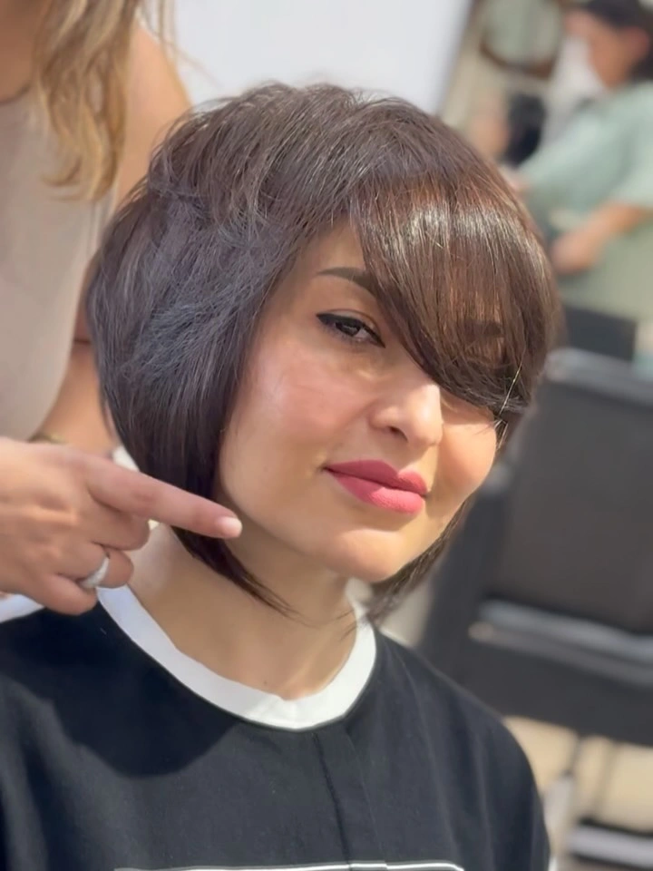 Short dark pixie bob with long side-swept fringe