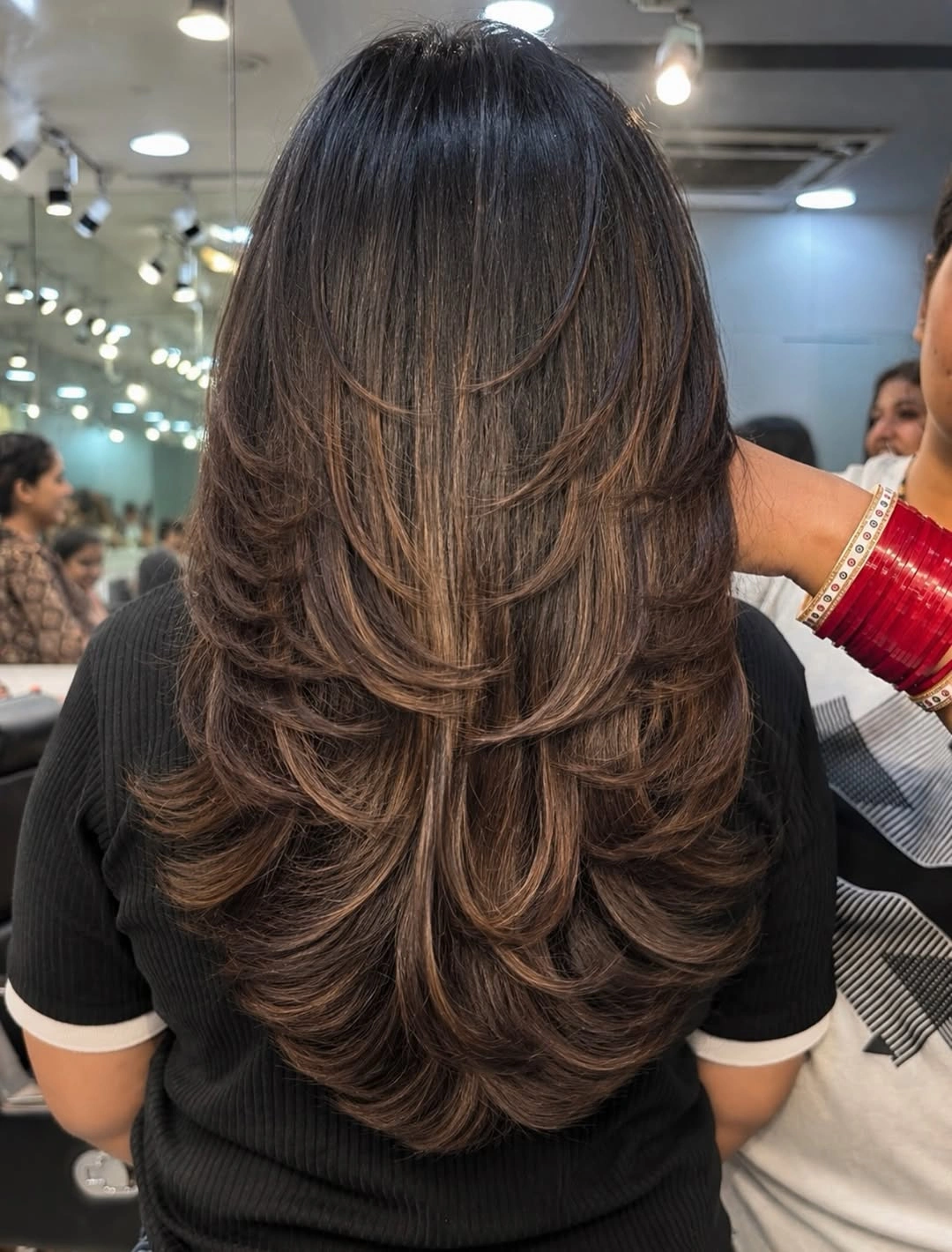Long brunette hair with cascading layers and warm highlights