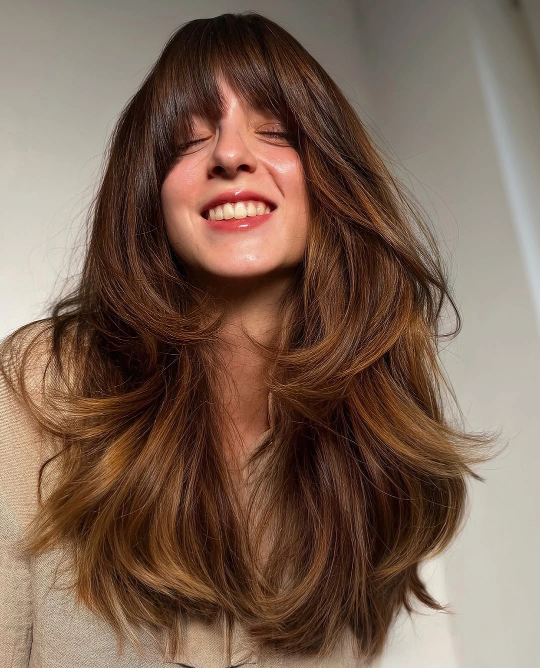 Long warm brunette wavy hair with full bangs