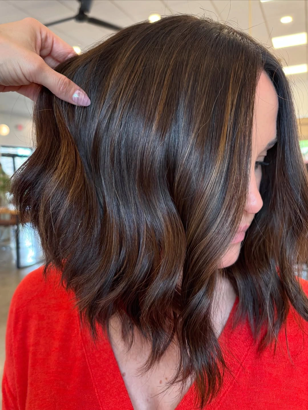 Dark brown wavy lob with subtle highlights from side