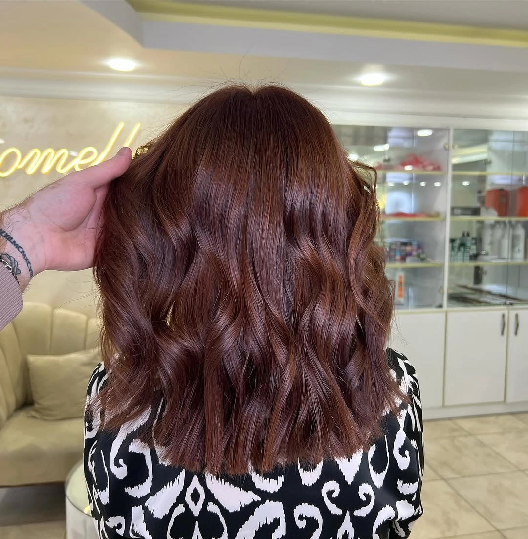Shoulder-skimming auburn wavy haircut from the back