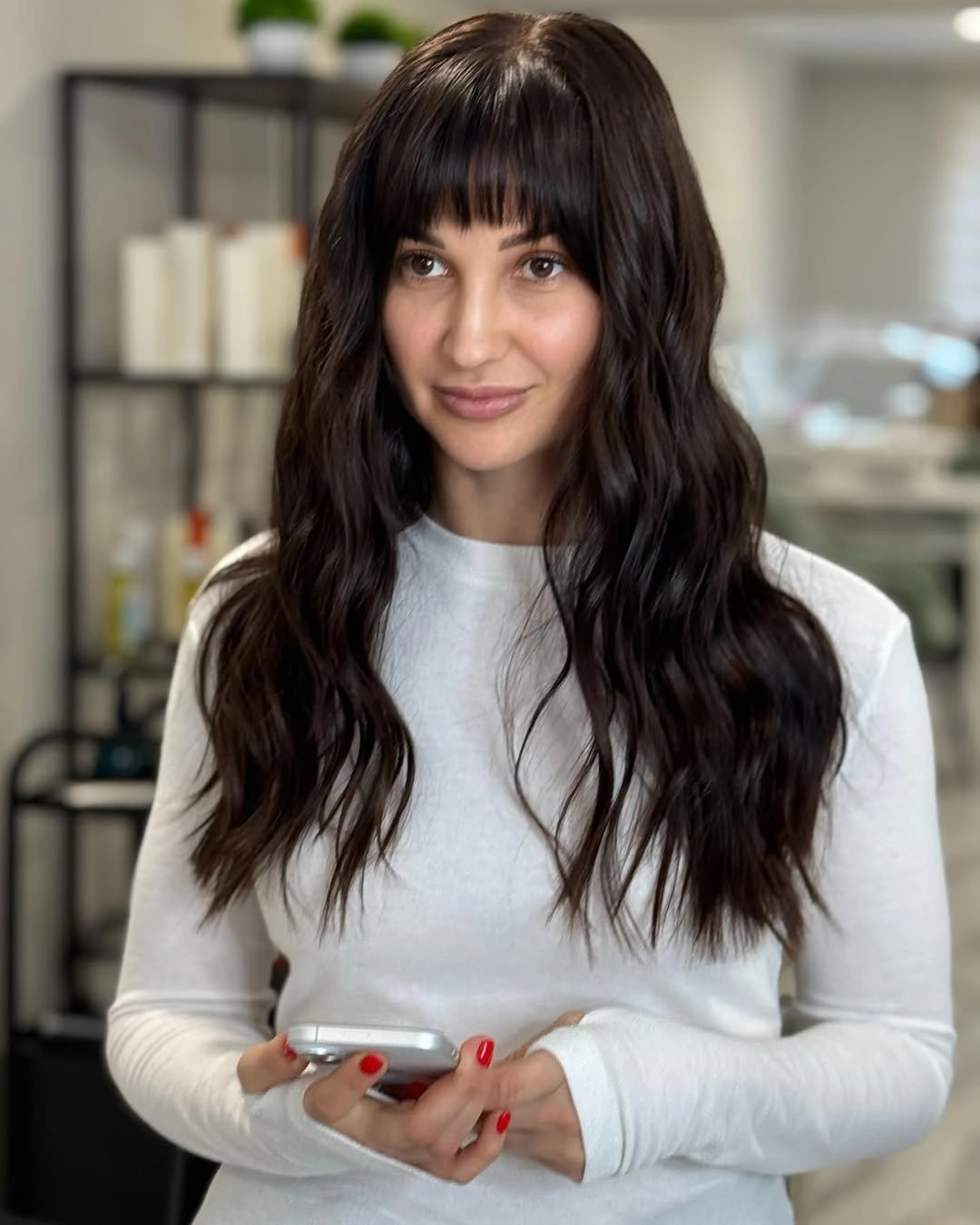 Long dark wavy hair with full straight-across bangs
