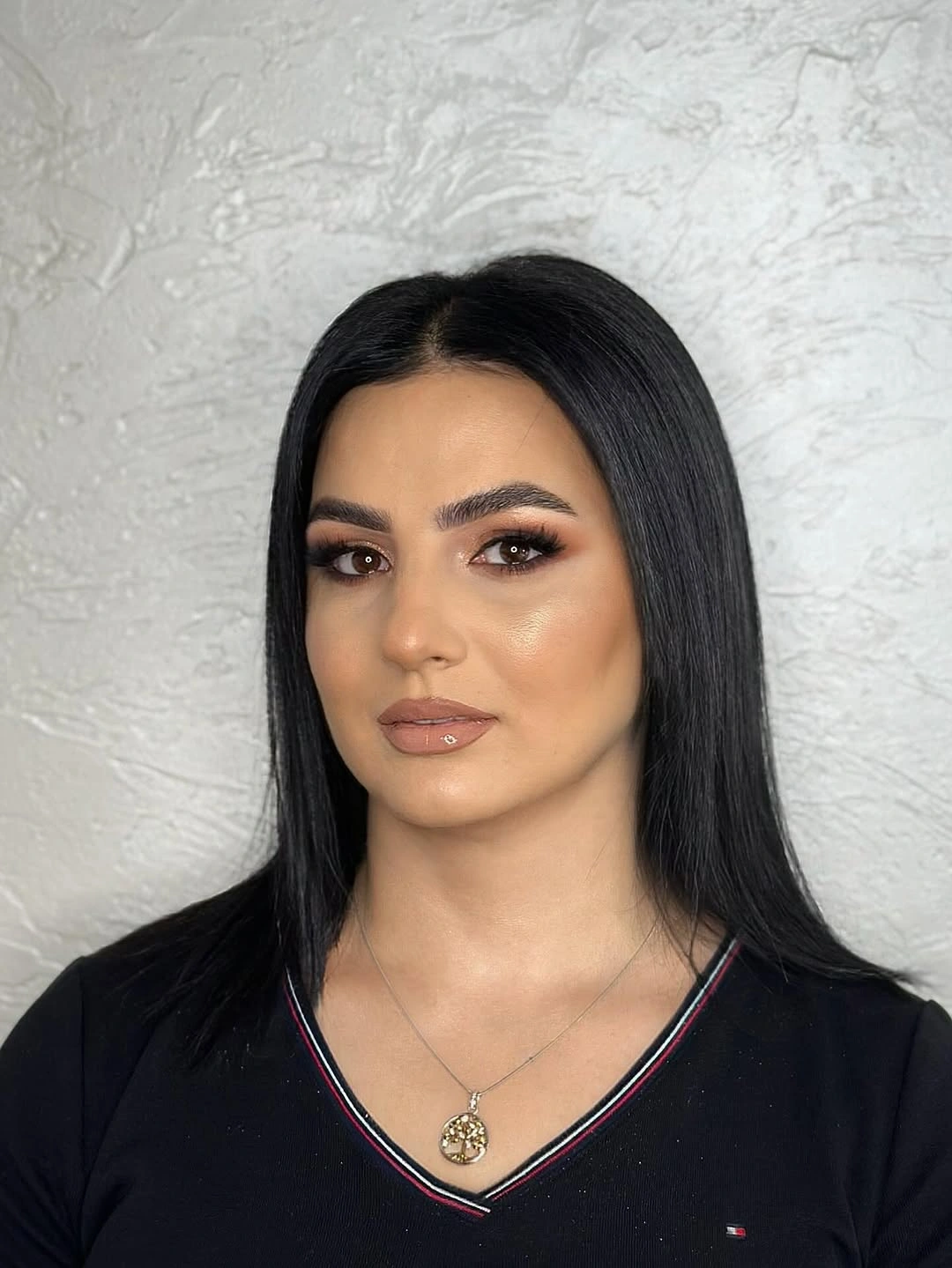 Sleek straight black medium-to-long hair with center part