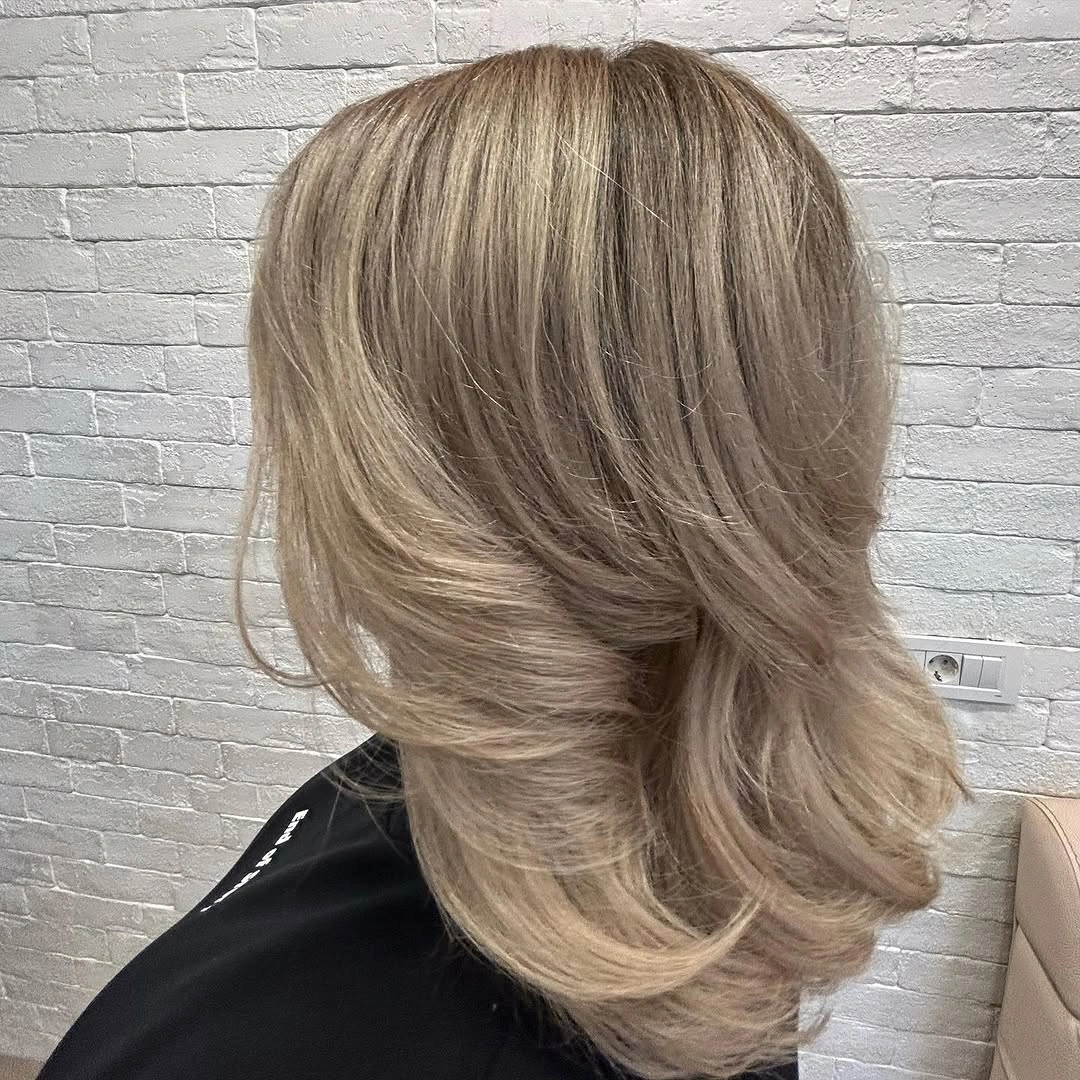 Blonde medium layered haircut with feathered curved ends