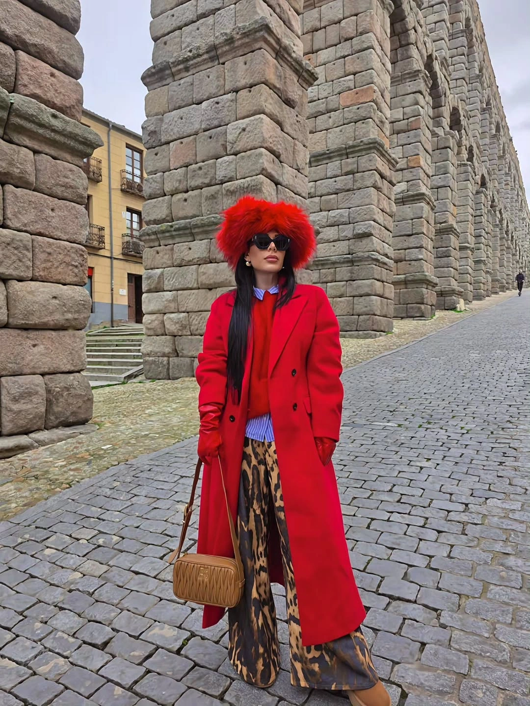 Red long coat with shaggy hat and patterned trousers