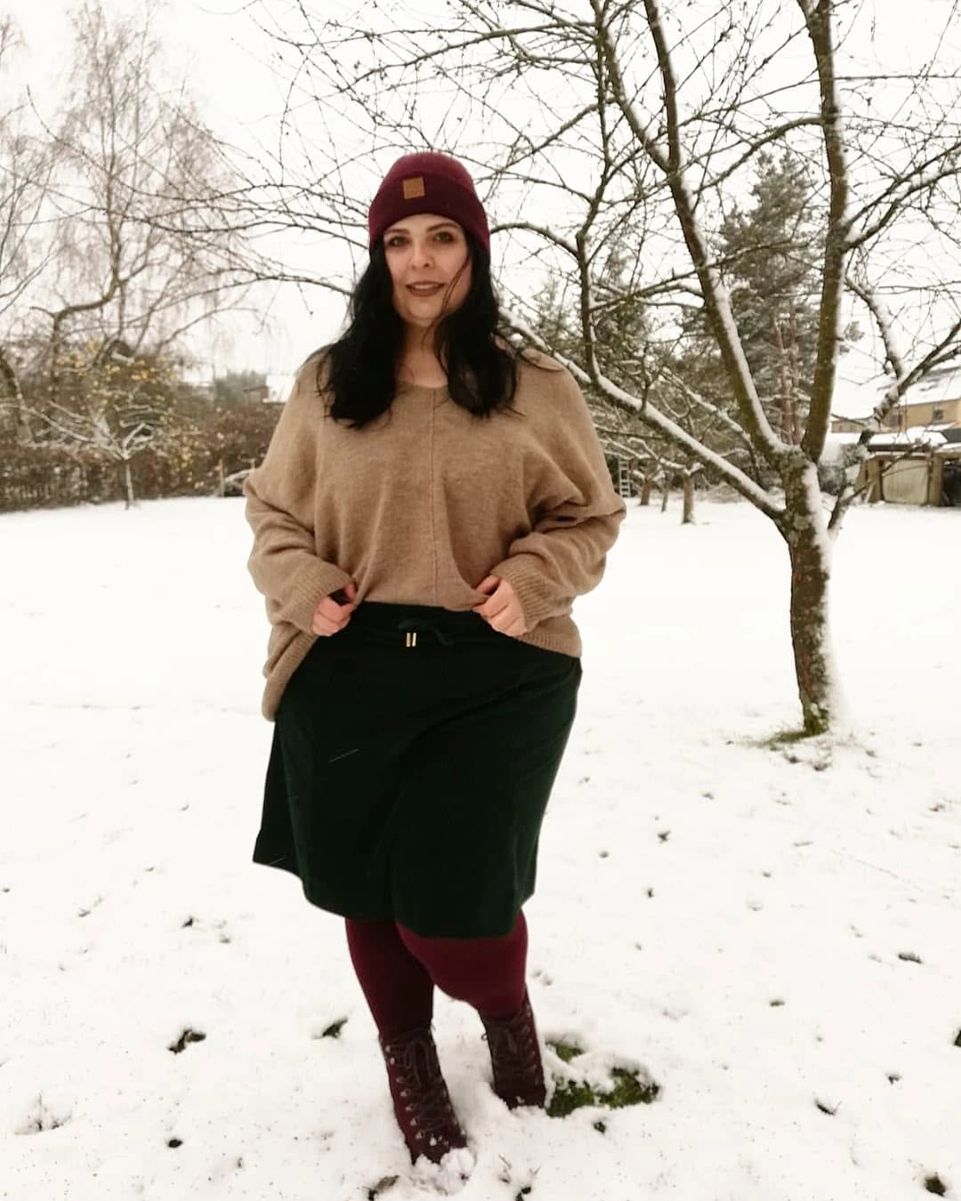 Beige sweater with burgundy beanie and tights in snow
