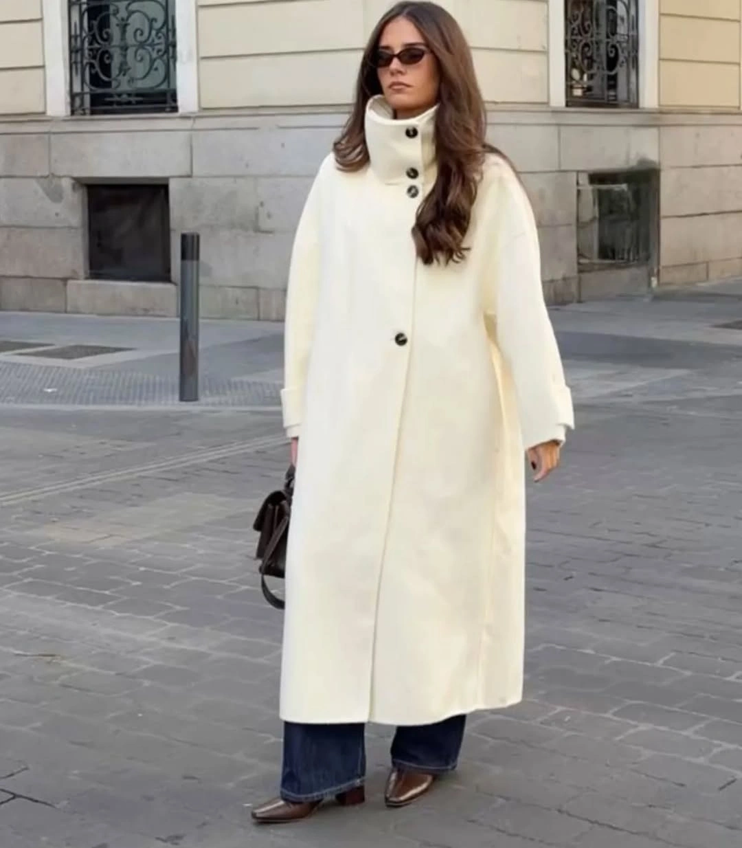 Long white coat with dark jeans and brown boots