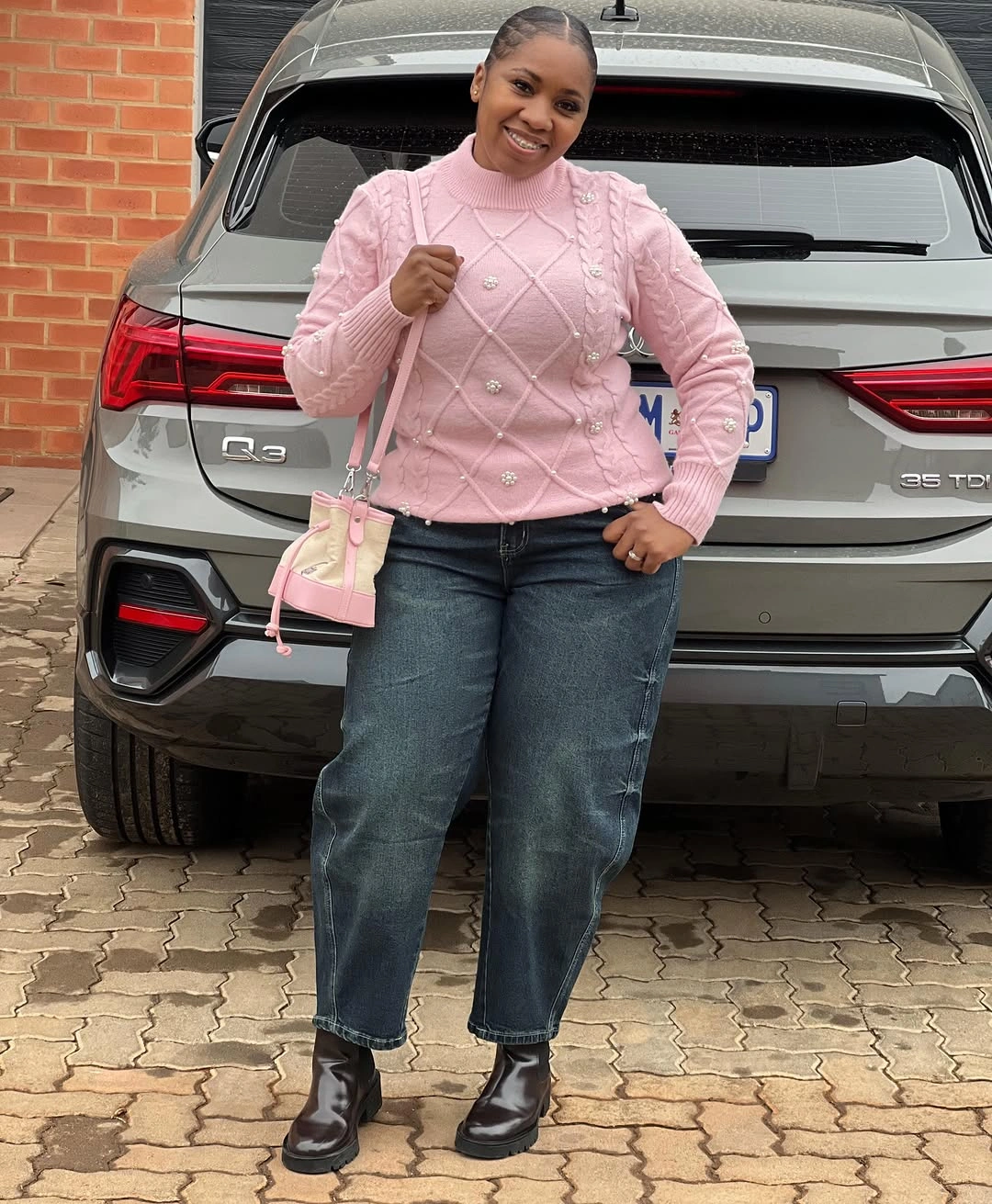Pink textured sweater with jeans and black boots