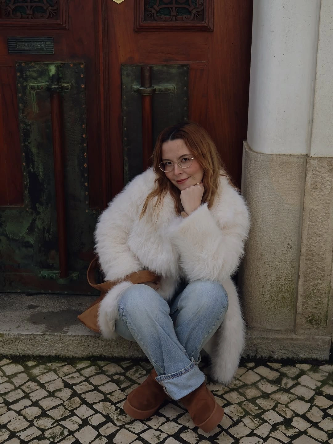 Fluffy white coat with cuffed jeans and tan boots
