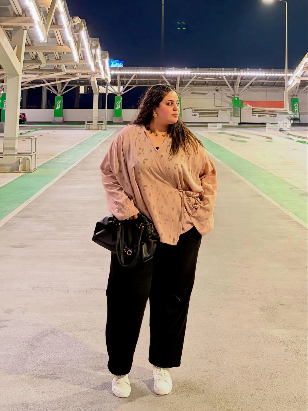 Blush draped blouse with black trousers and sneakers