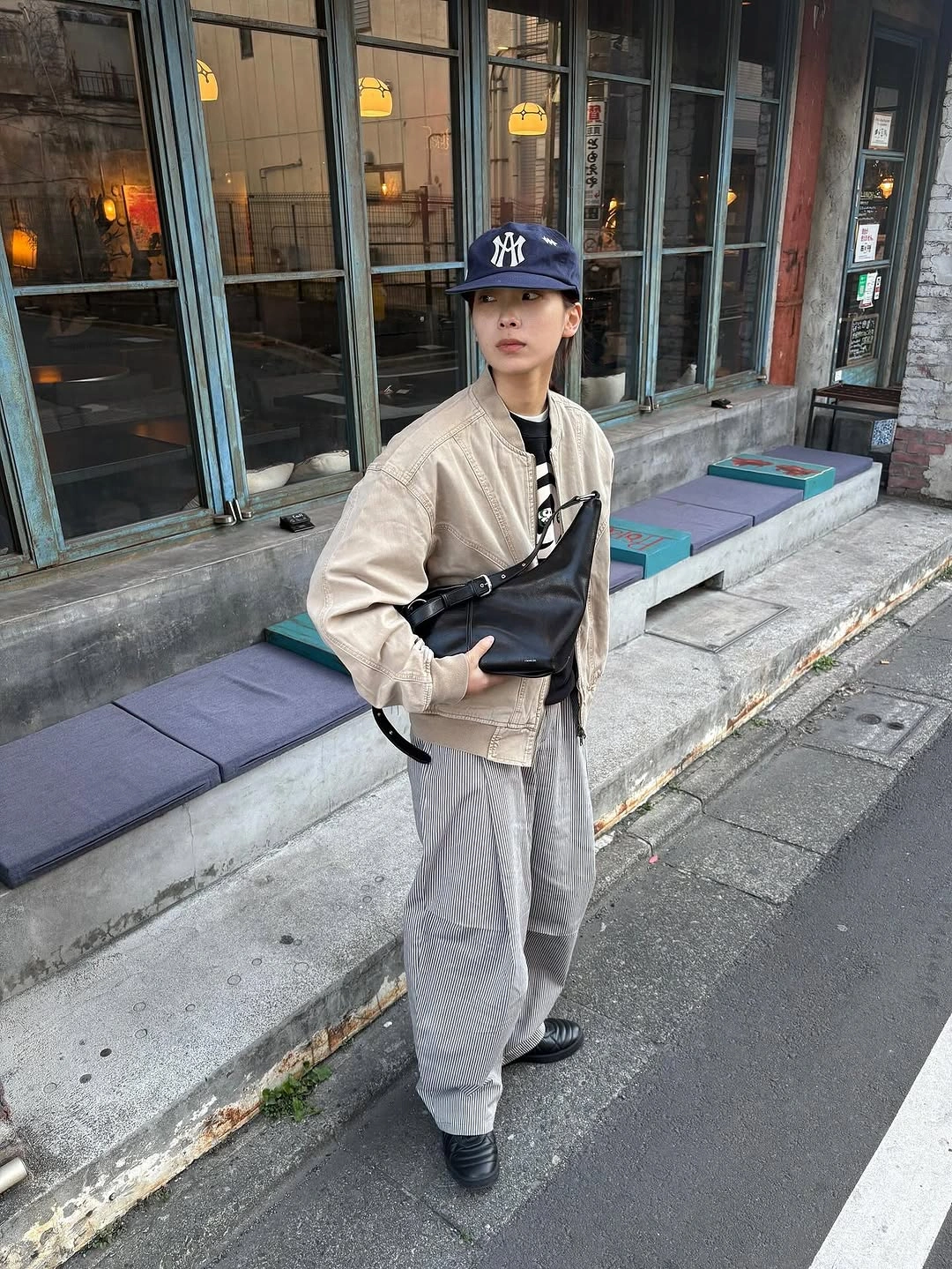 Beige short jacket with grey joggers and black crossbody bag