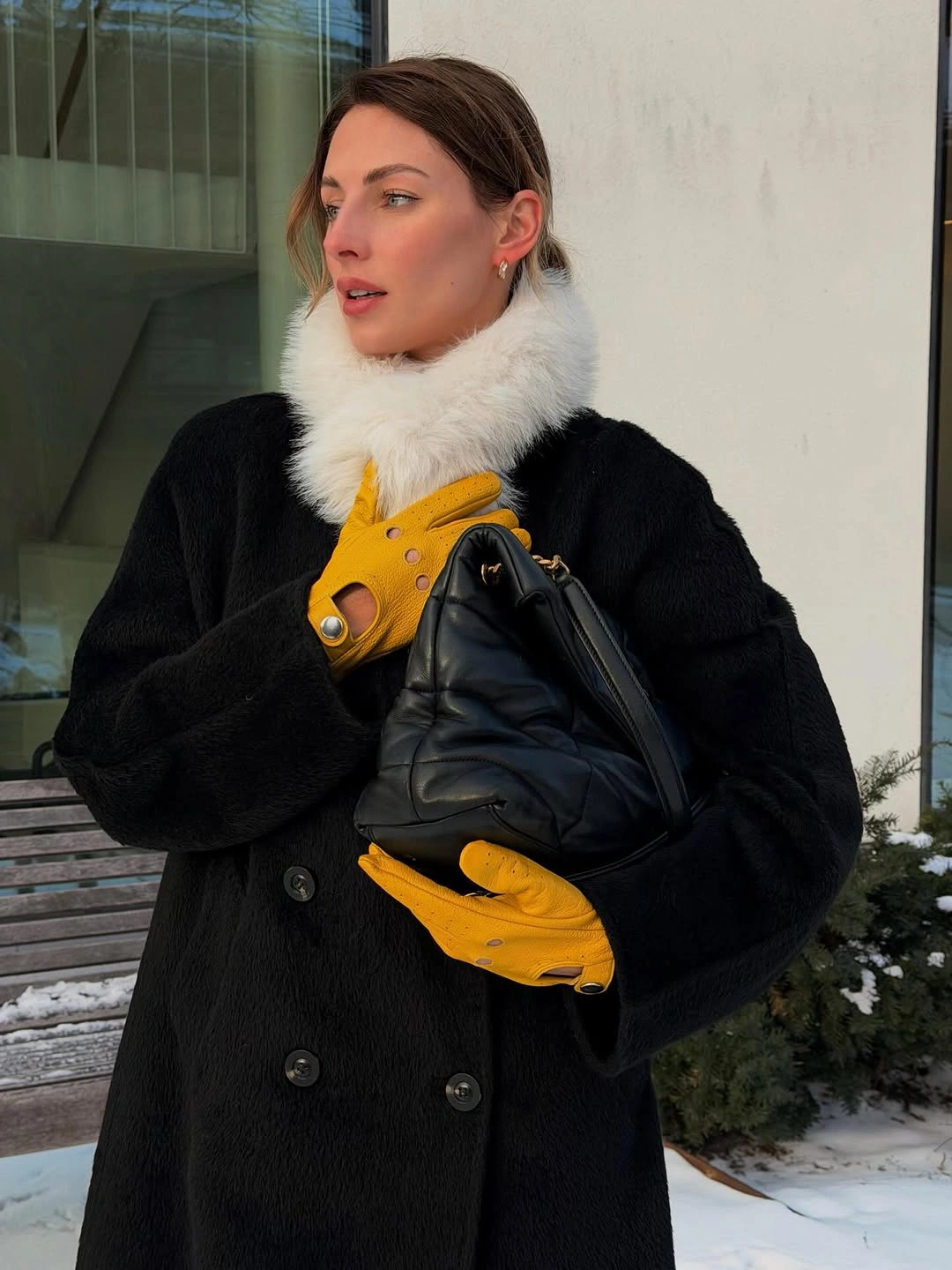 Black coat with white collar, yellow gloves and quilted bag