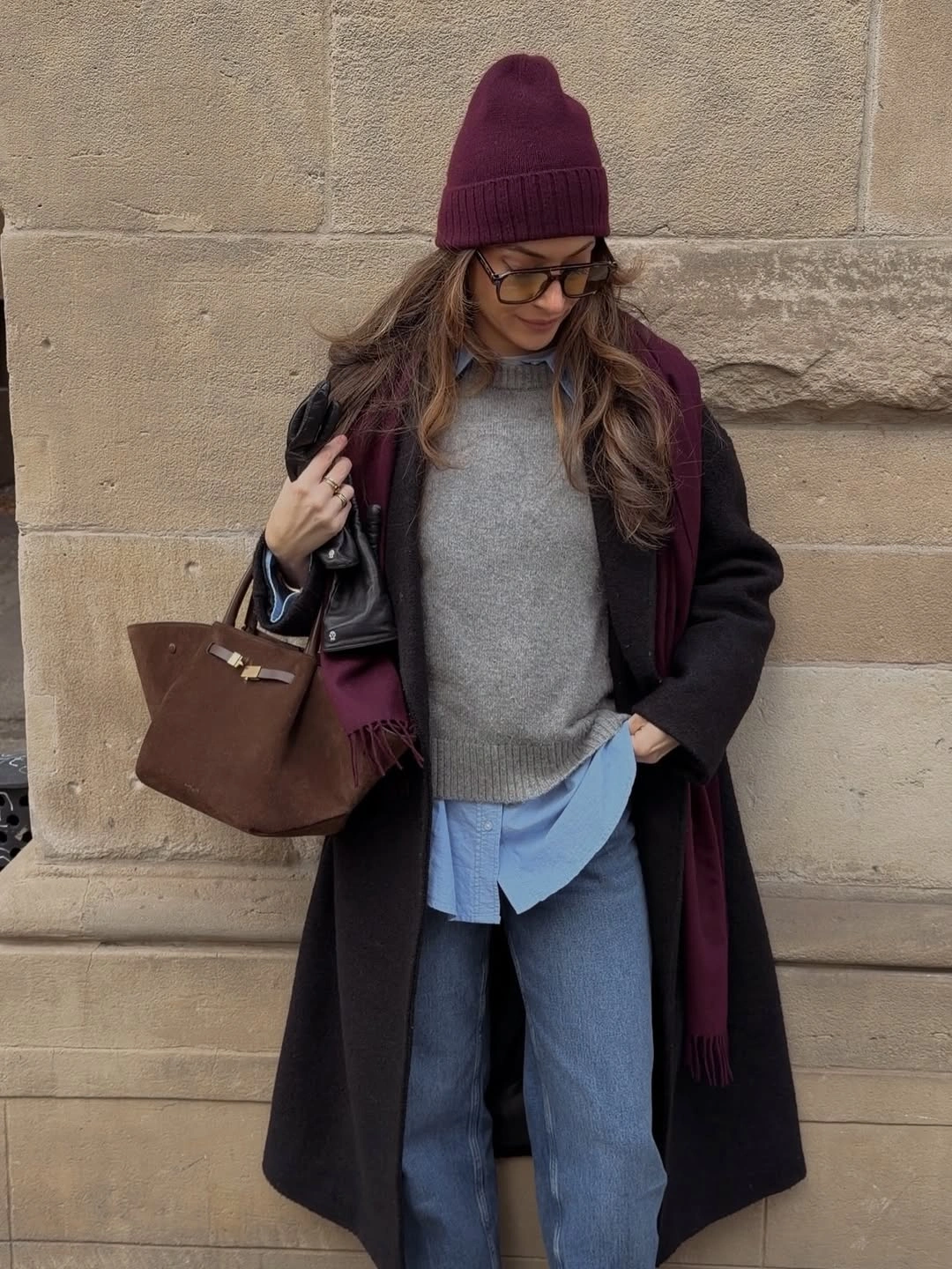 Maroon coat with grey sweater, blue shirt hem and jeans