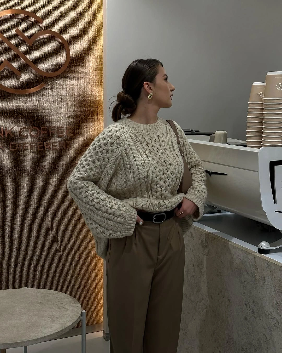 Cream cable sweater with olive-brown trousers in cafe
