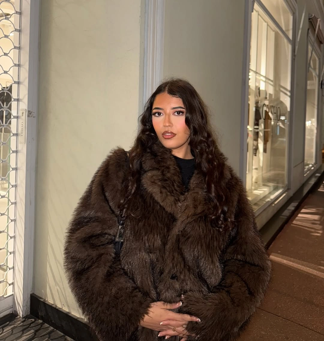 Dark oversized brown fur-style coat over dark outfit